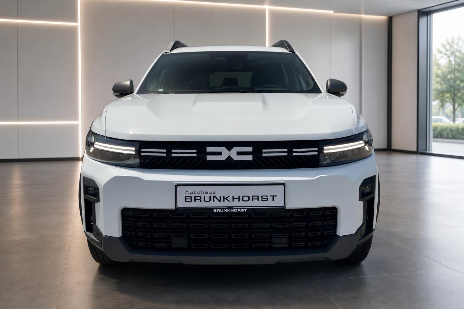 Dacia Bigster weiß, Frontansicht mit Kühlergrill im Showroom