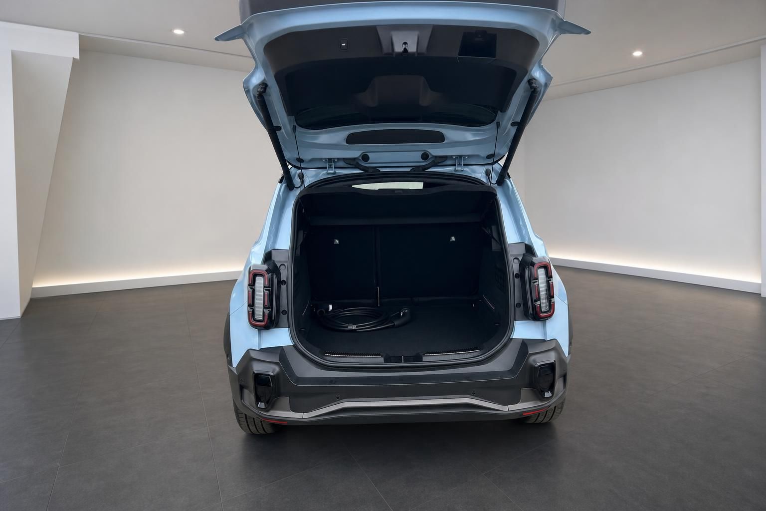 Renault Elektro-SUV in Hellblau mit geoeffnetem Kofferraum und Ladekabel