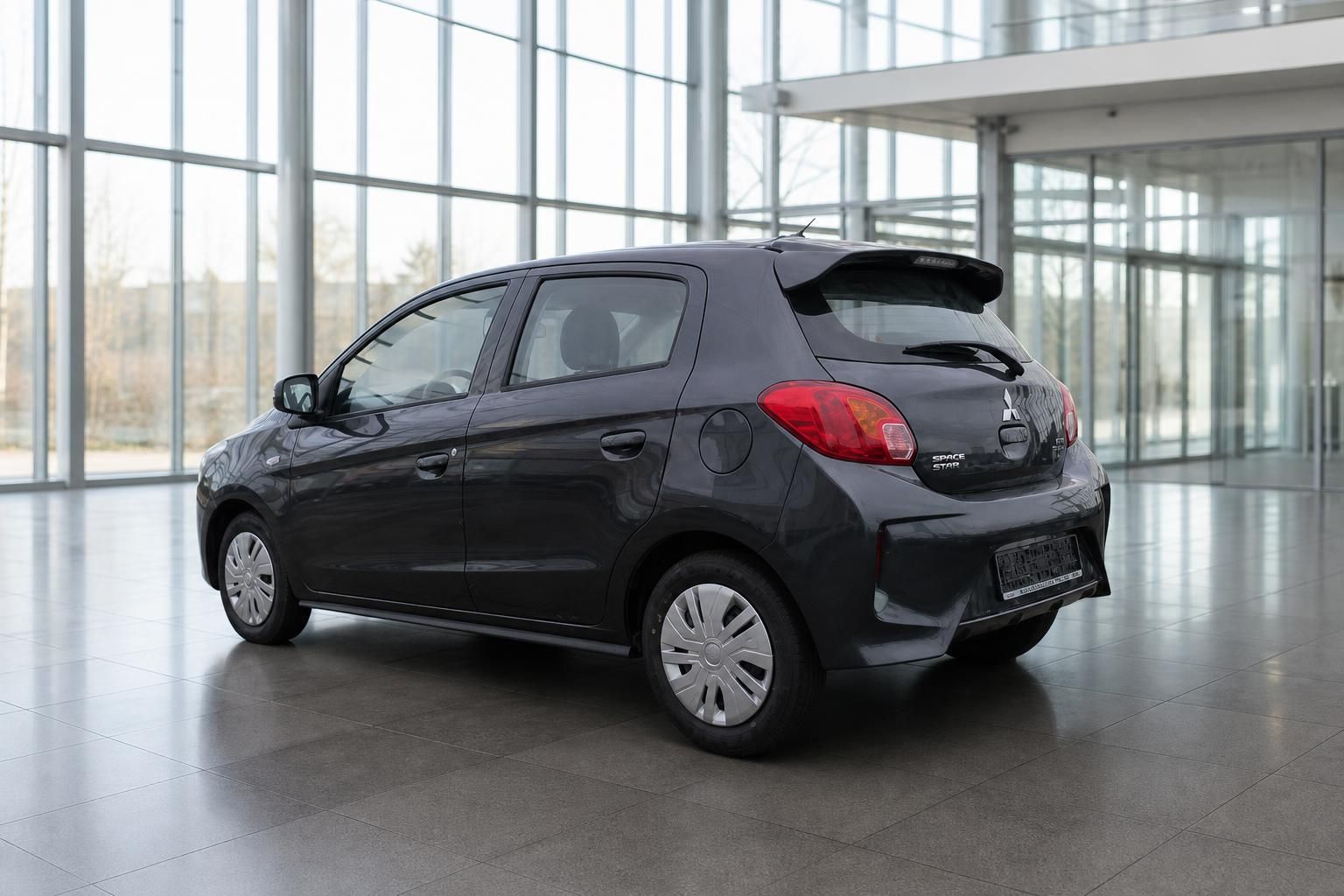 Mitsubishi Space Star dunkelgrau Heckansicht schräg im Autohaus mit Kennzeichen