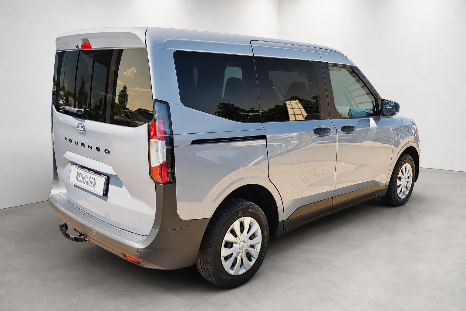Ford Tourneo Neuwagen in Silber, Seitenansicht von hinten mit Anhaengerkupplung