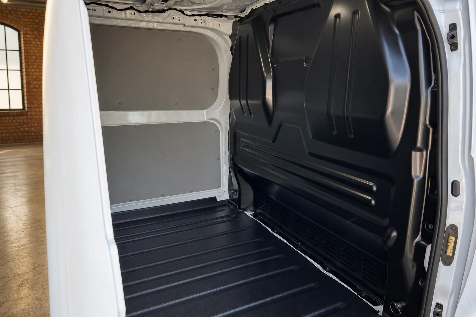Ford Transit Laderaum leer mit geöffneter Schiebetür, schwarzem Ladeboden und Trennwand