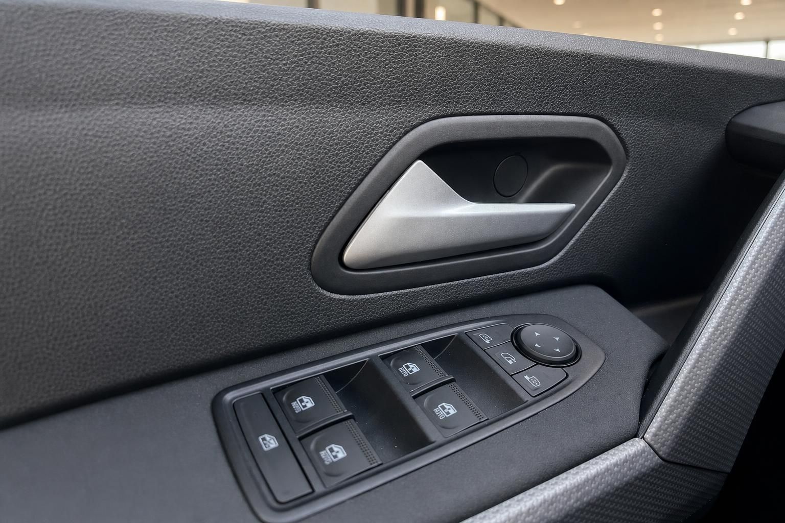 Türverkleidung mit Türgriff und Fensterheber-Bedienfeld im Dacia Innenraum