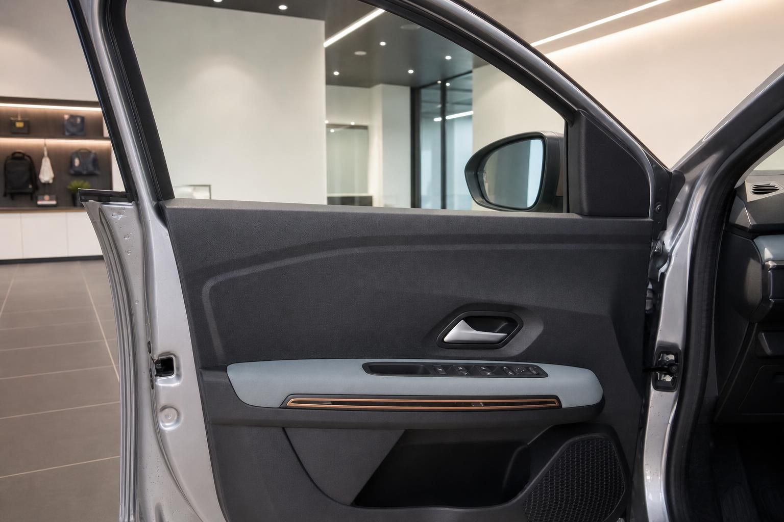 Detailansicht Fahrertuer mit Bedienelementen und Aussenspiegel im Dacia
