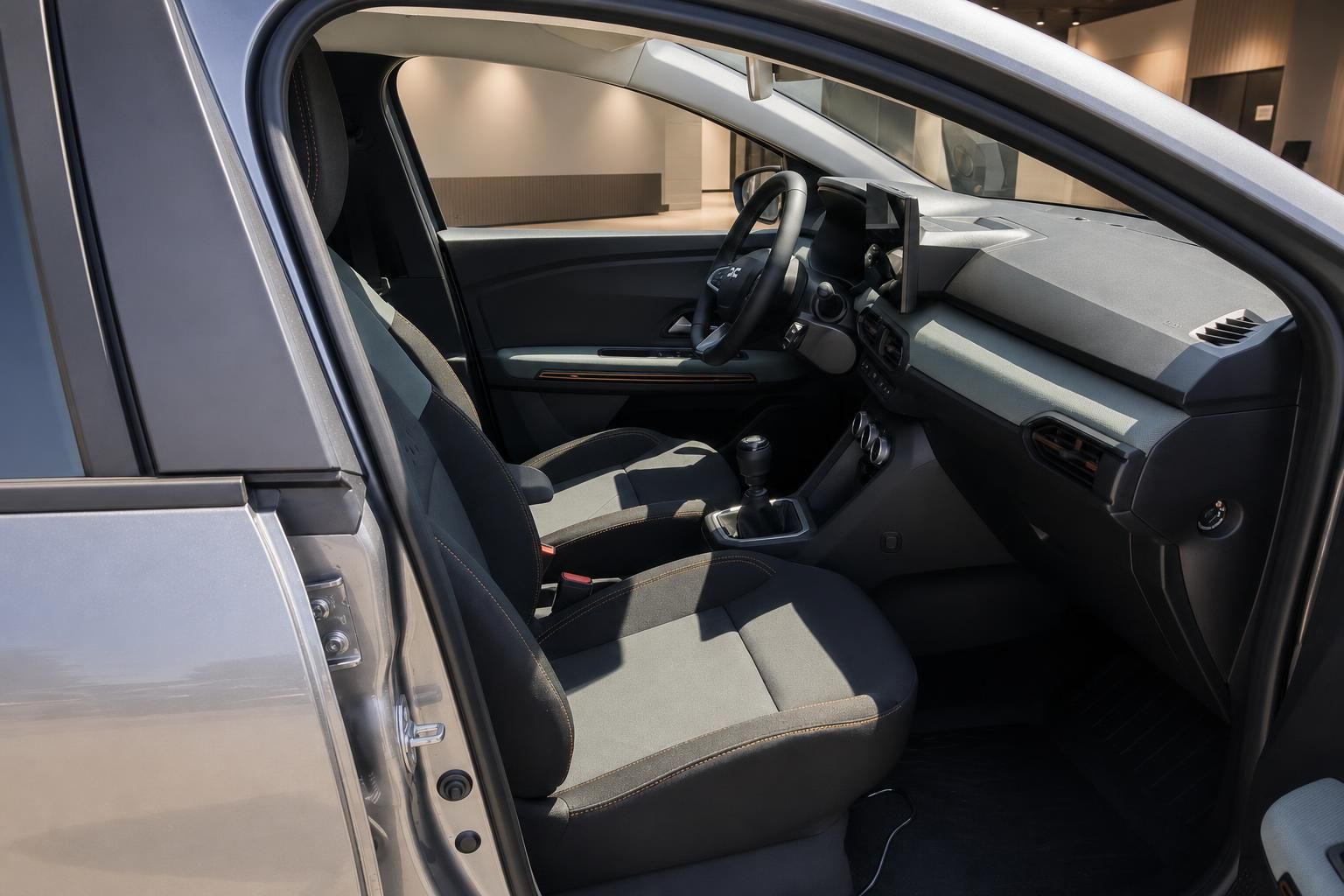 Innenraum Dacia mit Vordersitzen und Cockpit durch geoeffnete Fahrertuer