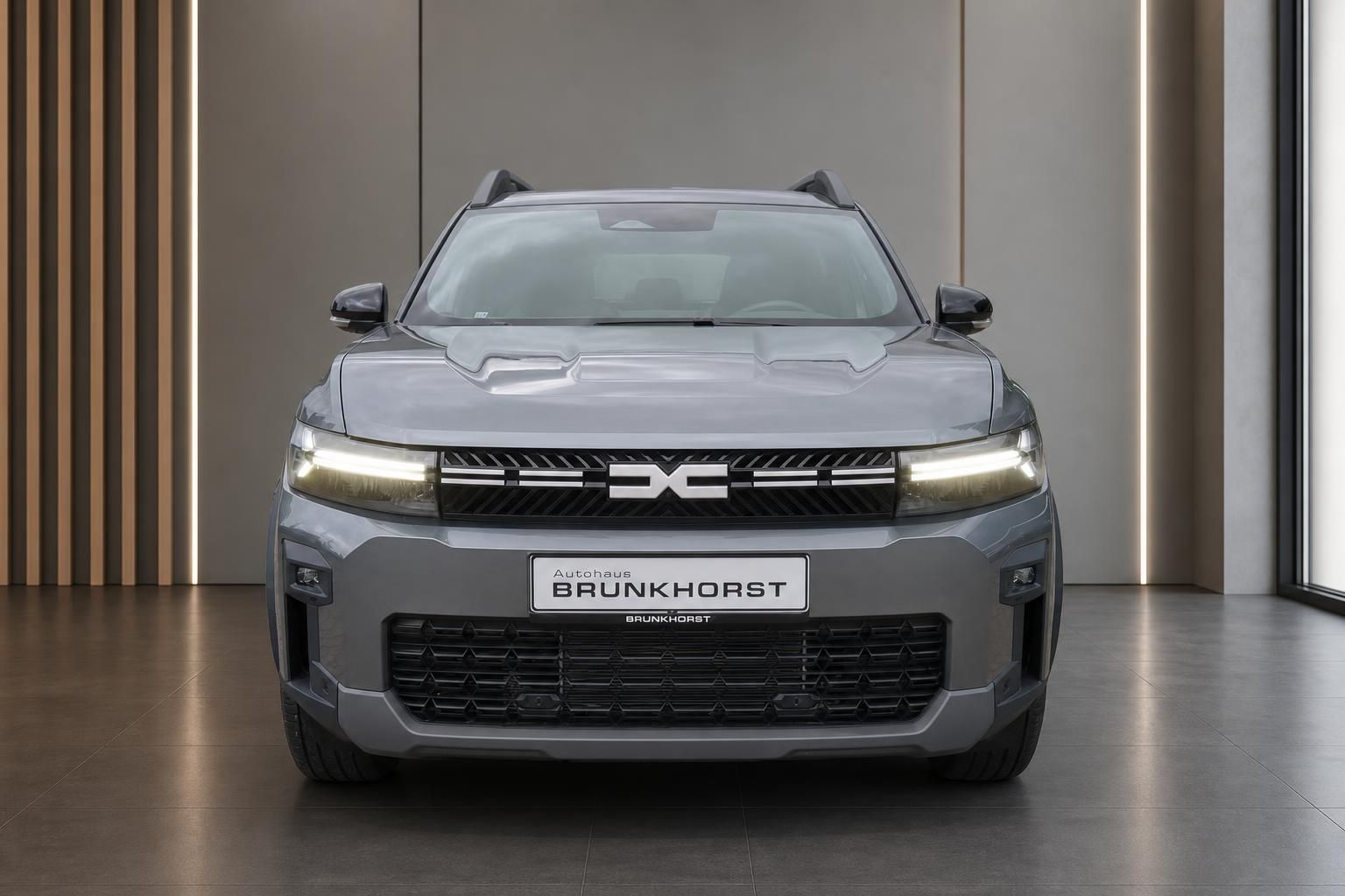 Dacia Bigster SUV Grau, Frontalansicht mit LED-Scheinwerfern im Autohaus