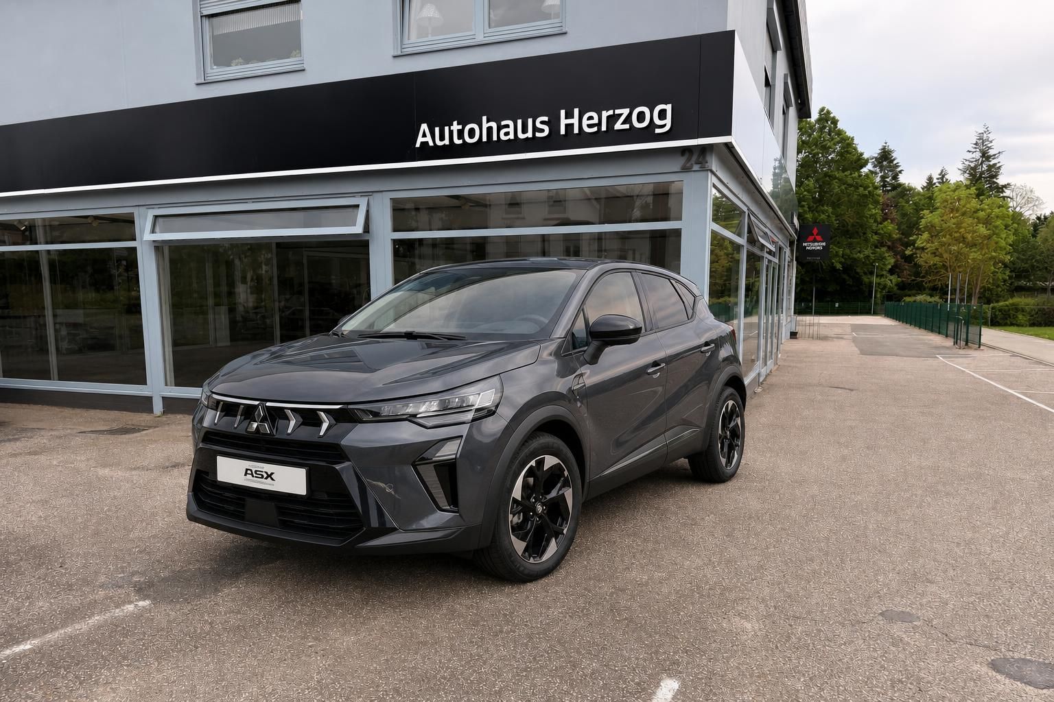Mitsubishi ASX grau Frontansicht schräg links vor Autohaus Herzog Händlergebäude