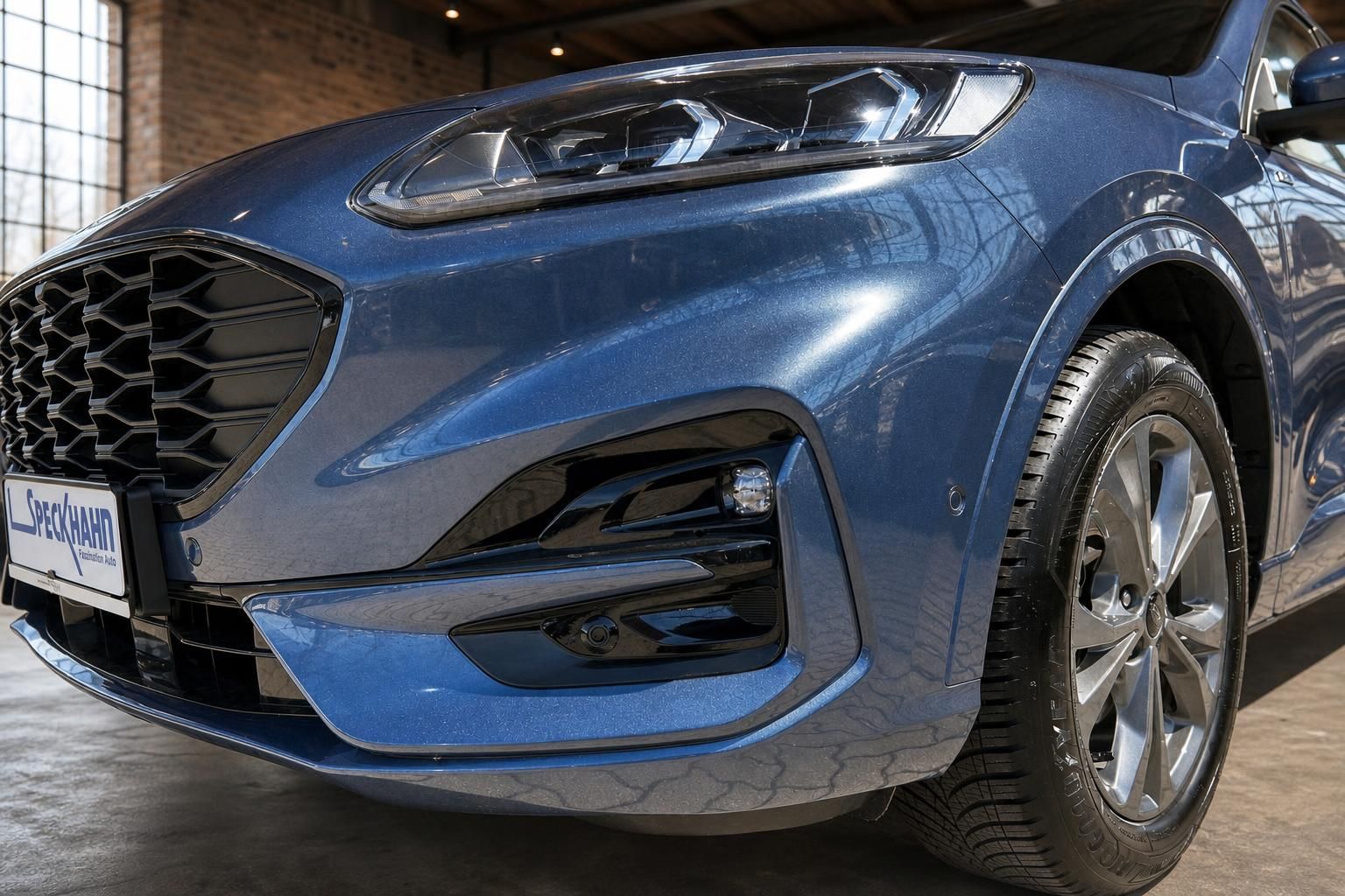 Ford in Blau, Detailansicht Frontstossstange, Scheinwerfer und Felge