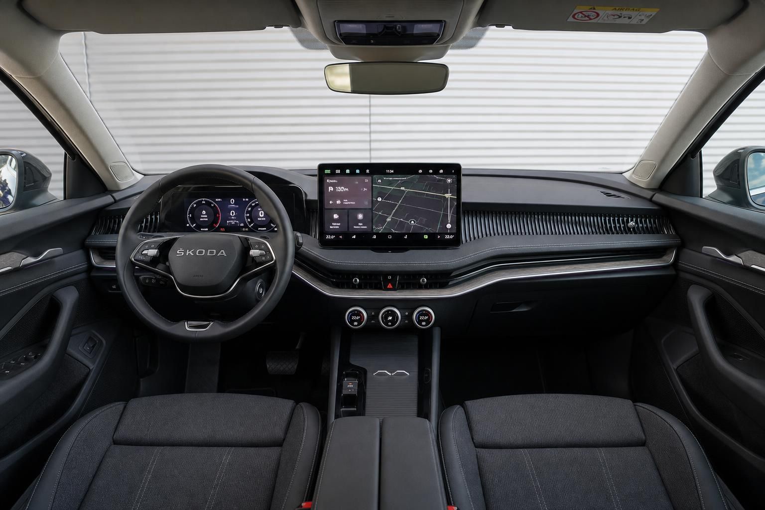 Übersicht Fahrzeug-Armaturenbrett mit Skoda-Lenkrad und zentralem Touchscreen