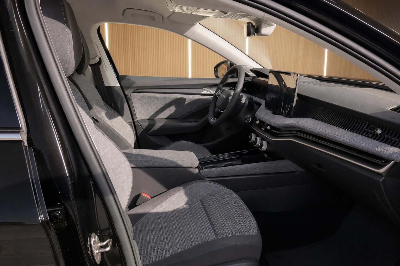 Moderner Fahrzeuginnenraum mit grauem Stoff-Interieur und zentralem Touchscreen-Display