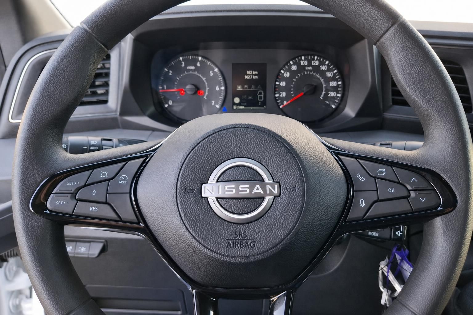Nissan Lenkrad mit Multifunktionstasten und Kombiinstrument im Fahrzeugcockpit