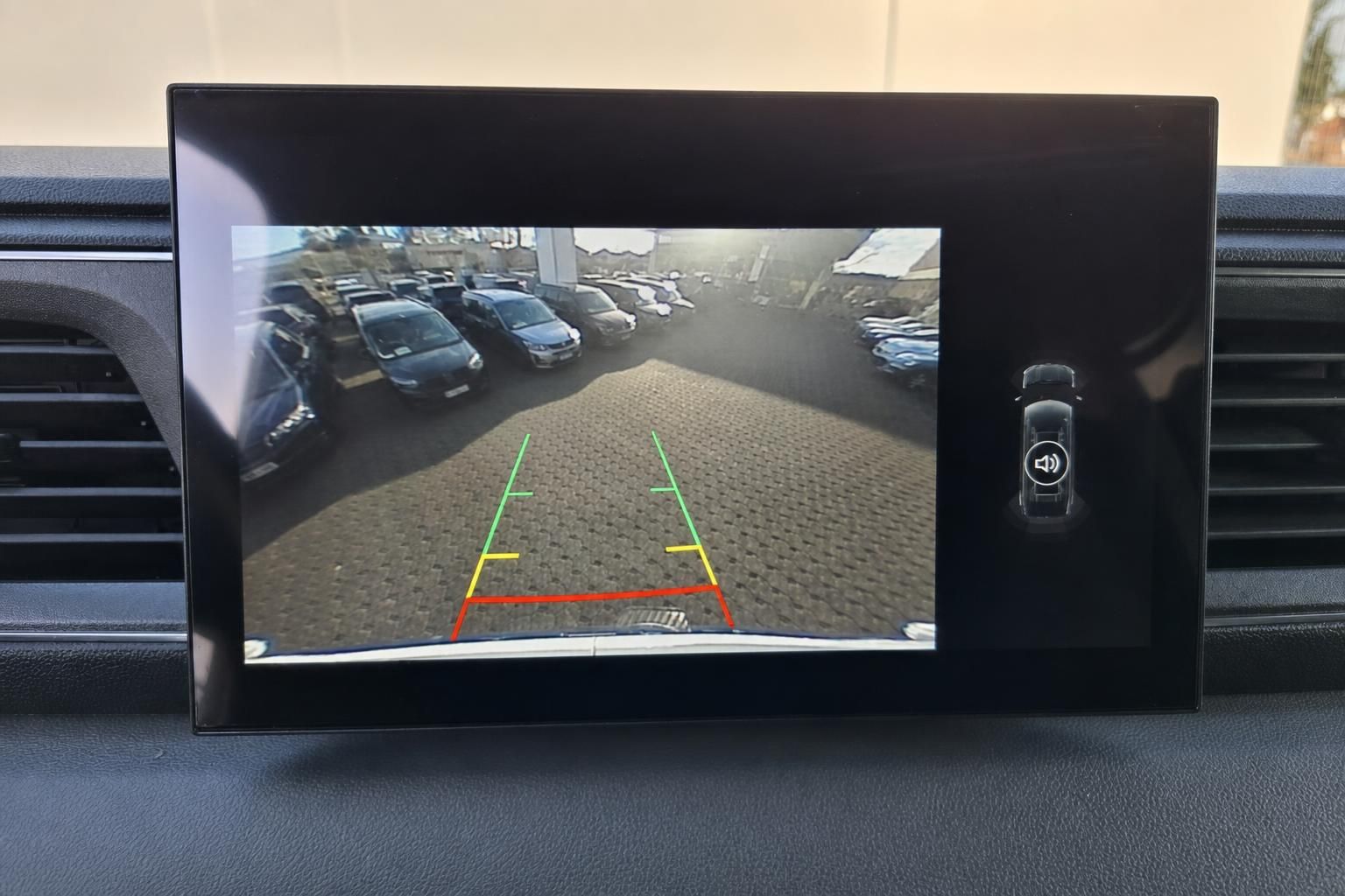 Rückfahrkamera-Display mit farbigen Hilfslinien und Parkplatzansicht im Fahrzeug-Infotainmentsystem