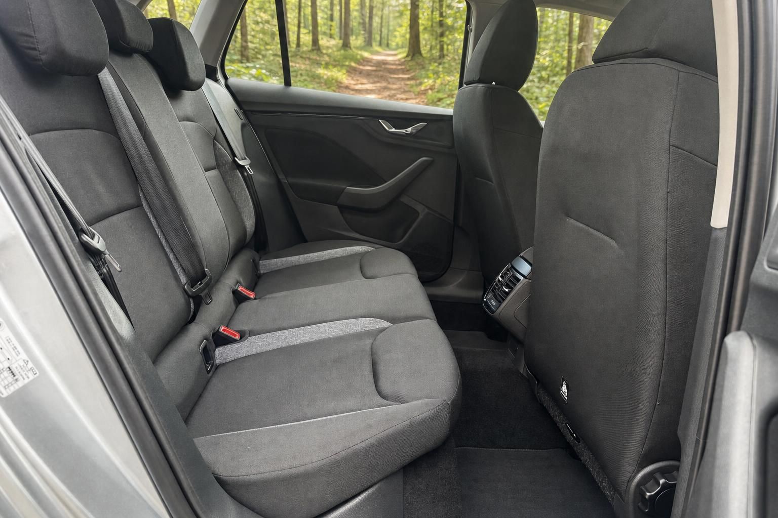 Skoda Fahrzeug Rücksitze und Innenraum mit grauen Polstern und Waldblick durch Fenster