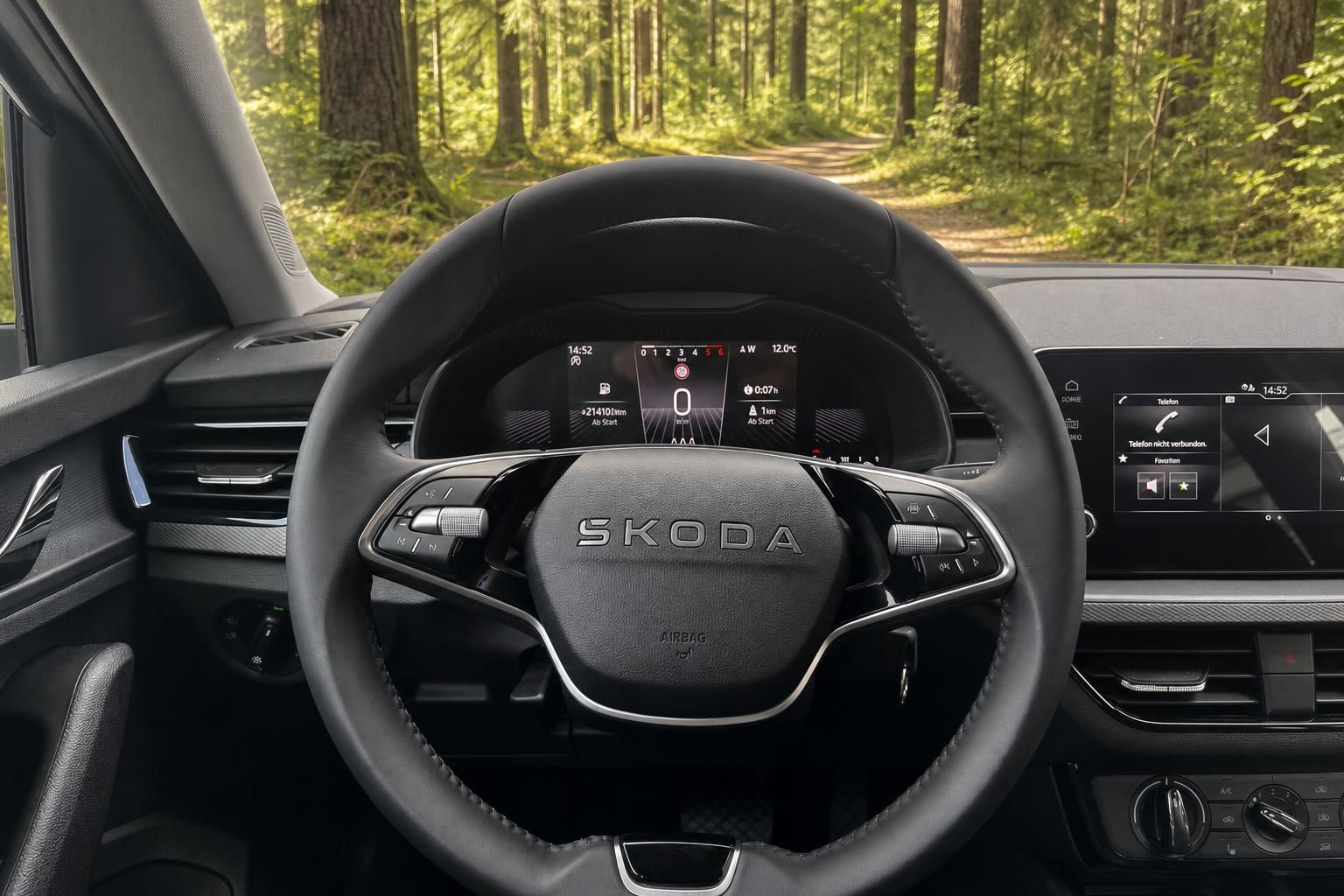 Skoda Fahrzeug Innenraum mit Lenkrad und digitalem Cockpit Display im Waldgebiet