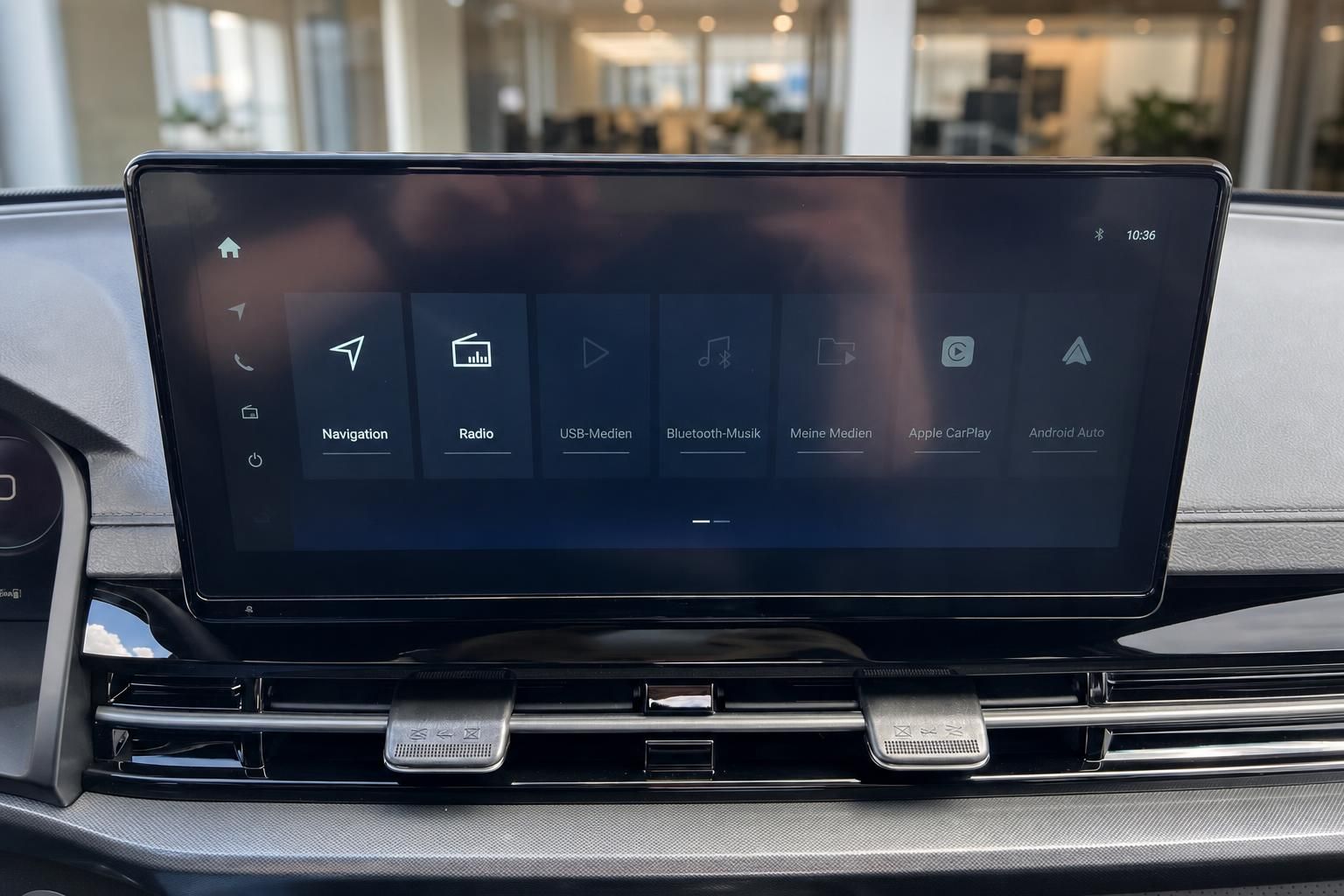 Infotainment-Display mit Navigationsmenu und Medien-Optionen im Auto