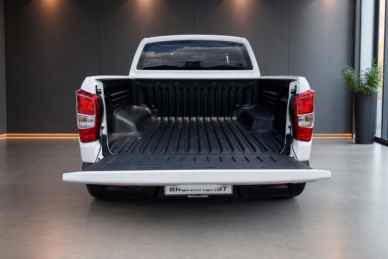 Weißer Pickup-Truck mit offener Ladefläche - Heckansicht im Autohaus-Showroom