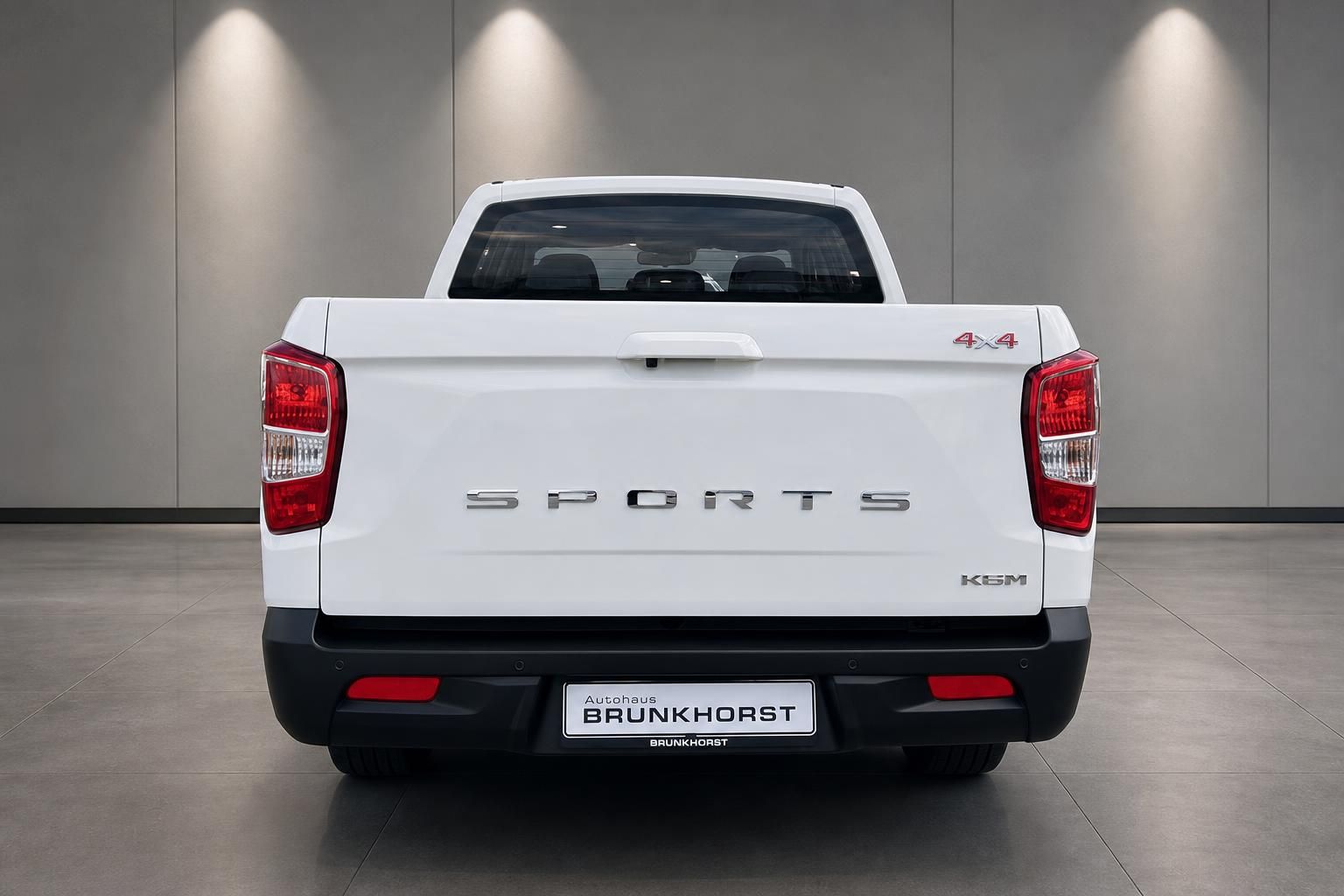 Weißer SsangYong Sports Pick-up 4x4 Heckansicht mit LED-Rückleuchten im Showroom