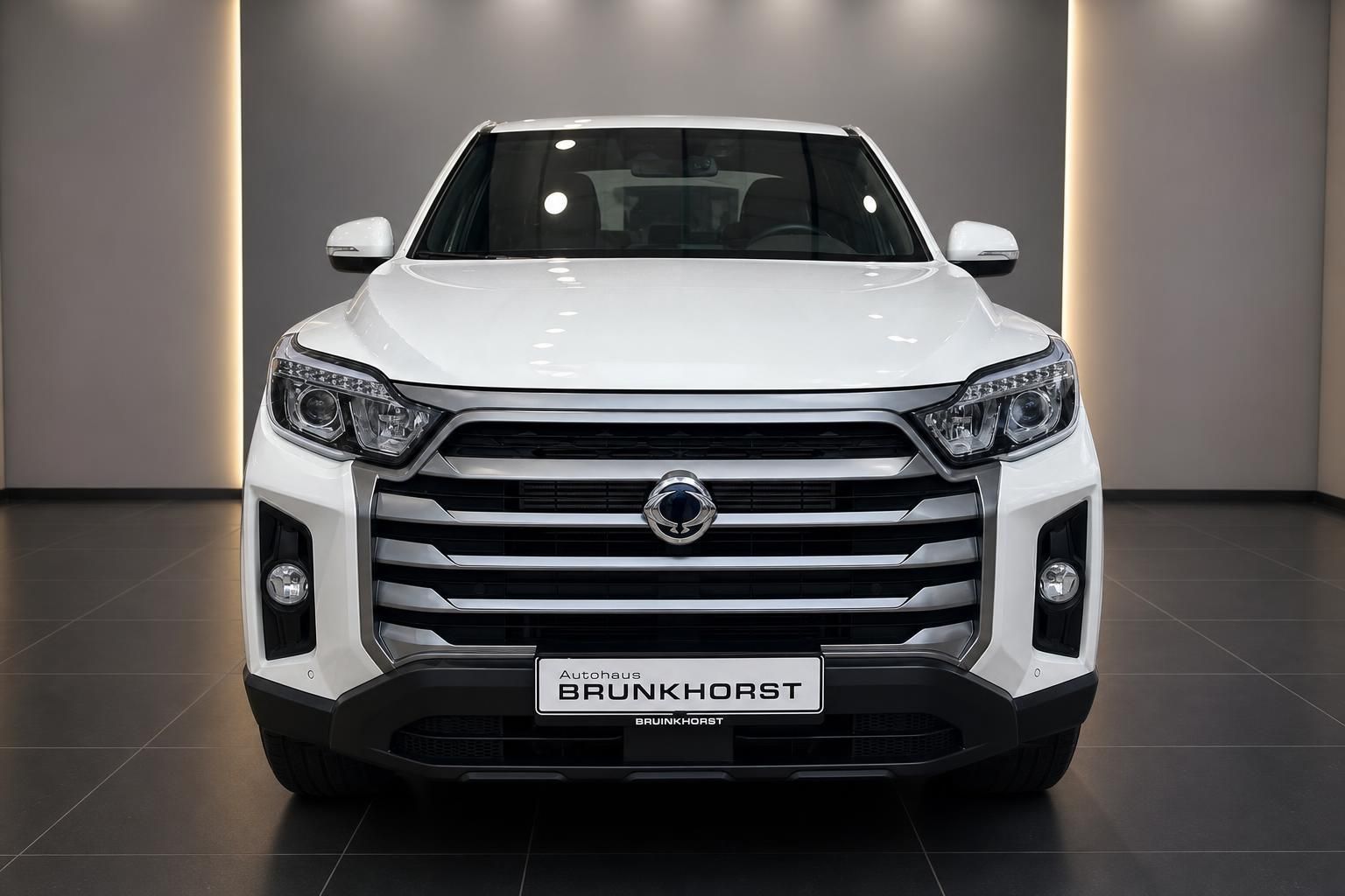 Weißer SsangYong Sports Pick-up Frontansicht mit LED-Scheinwerfern und Kühlergrill