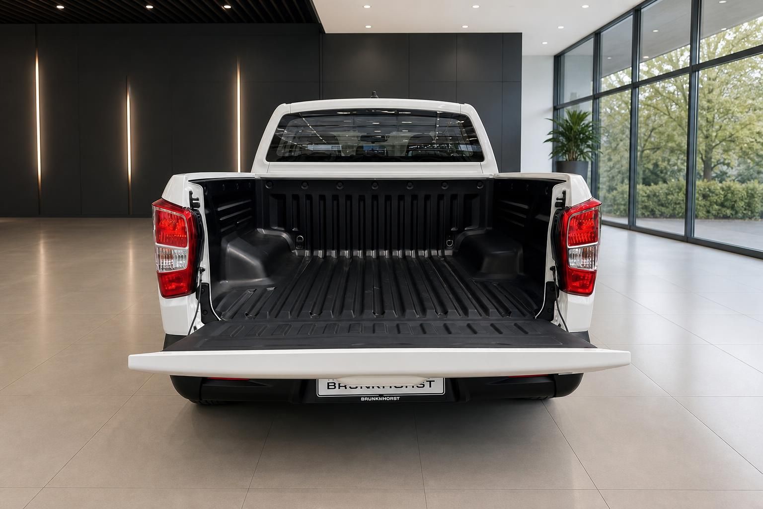 Weißer Pickup mit geoeffneter Ladeflaeche und heruntergeklappter Heckklappe