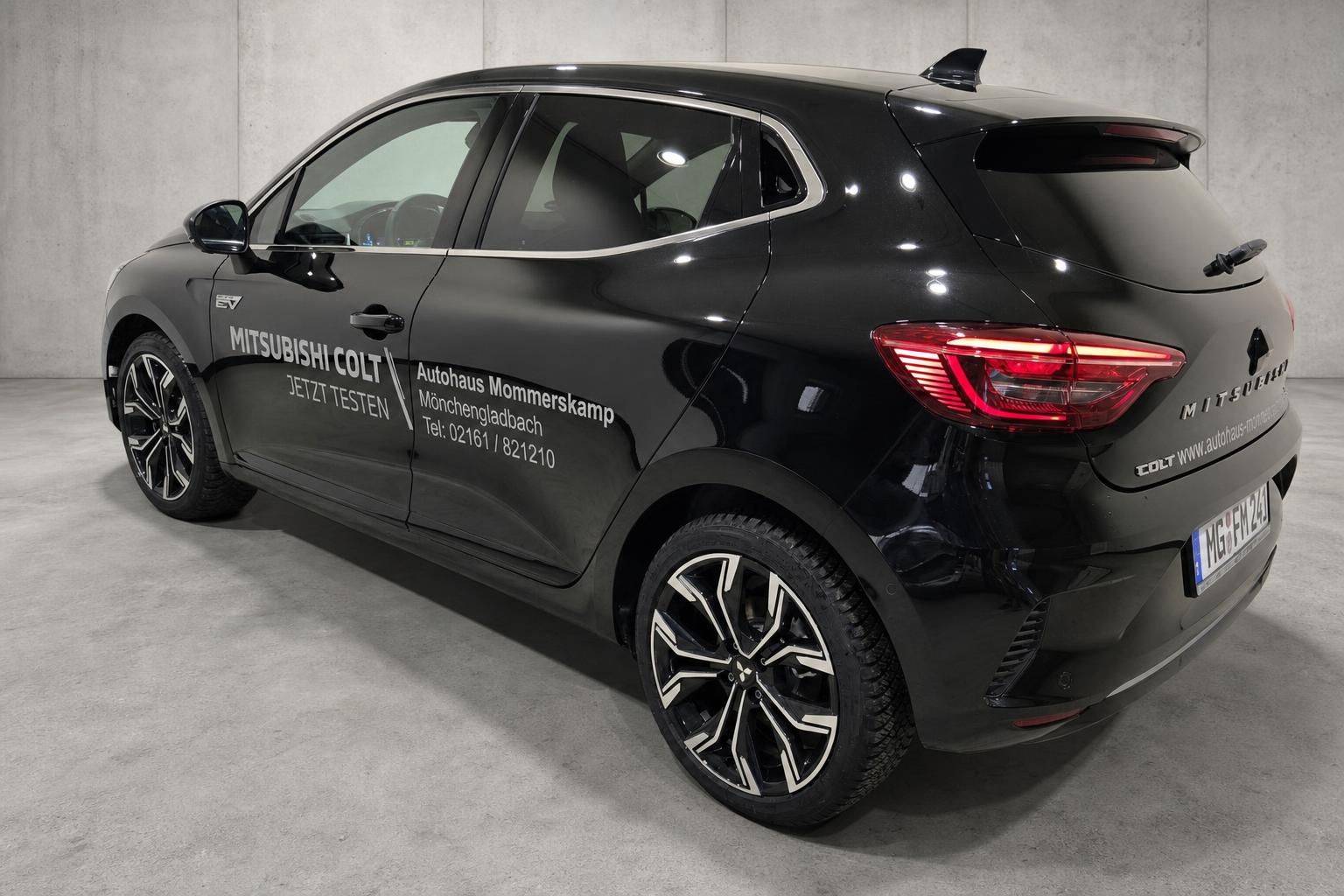 Mitsubishi Colt schwarz, Heckansicht schraeg, Alufelgen und Ruecklichter