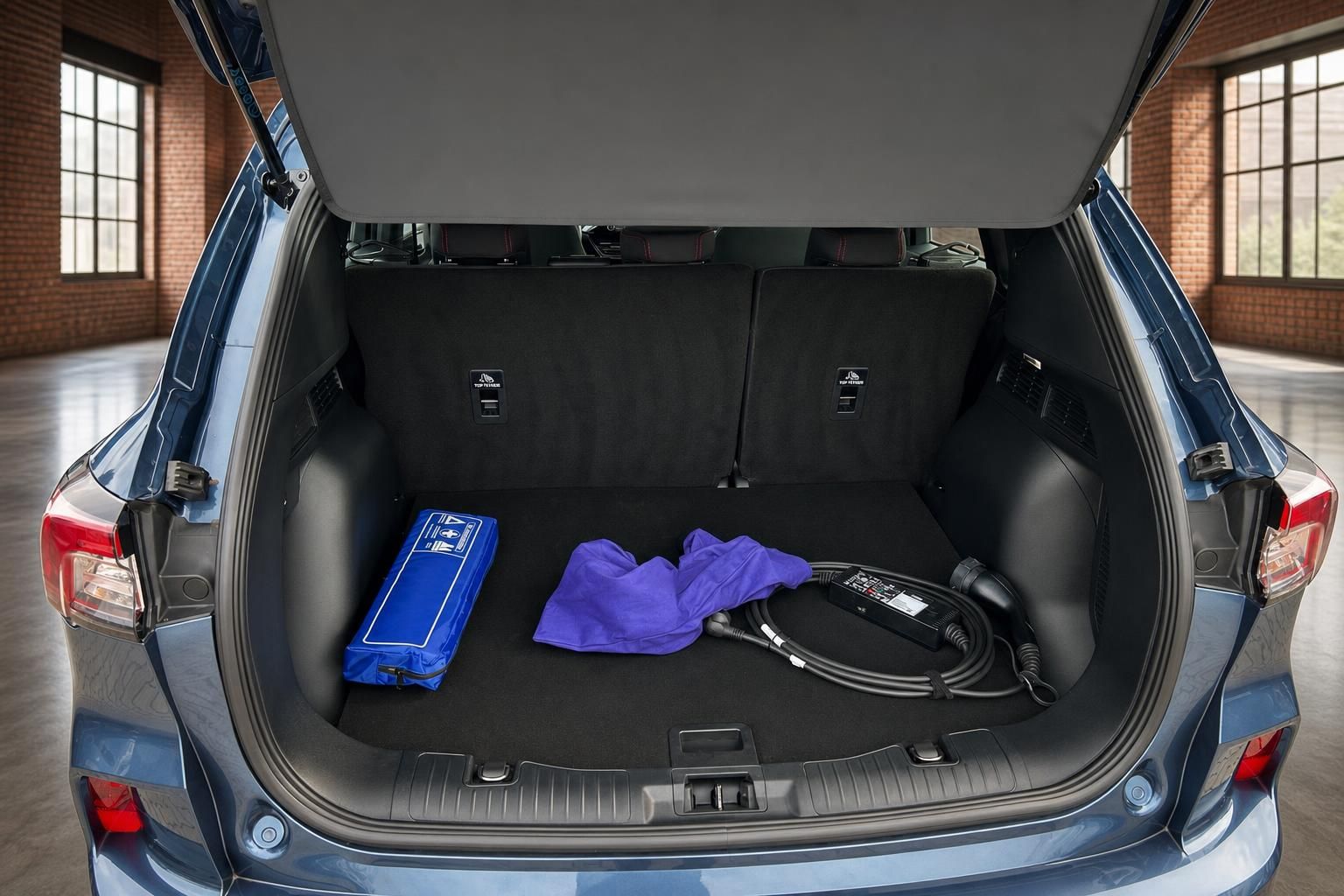 Ford Kuga Kofferraum mit Ladekabel und Zubehoer in blauer Lackierung