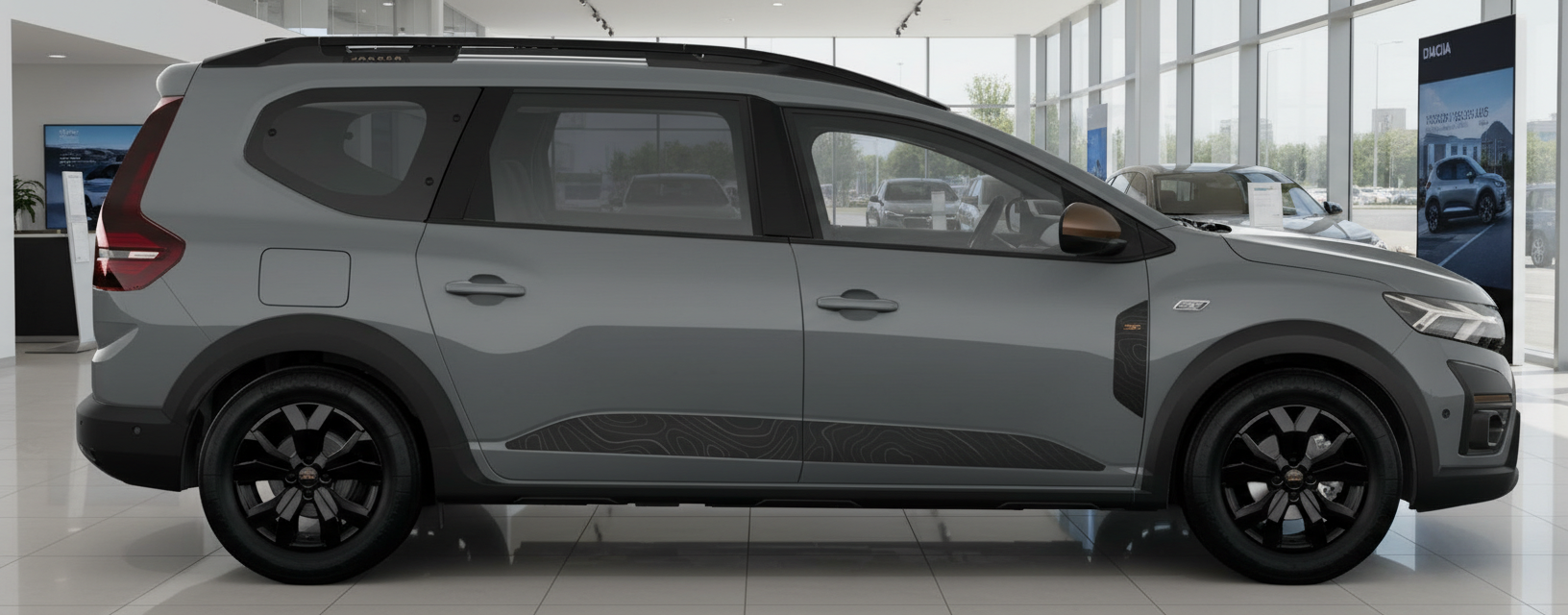 Grauer Dacia Jogger Seitenansicht im Autohaus mit schwarzen Felgen und Dachreling