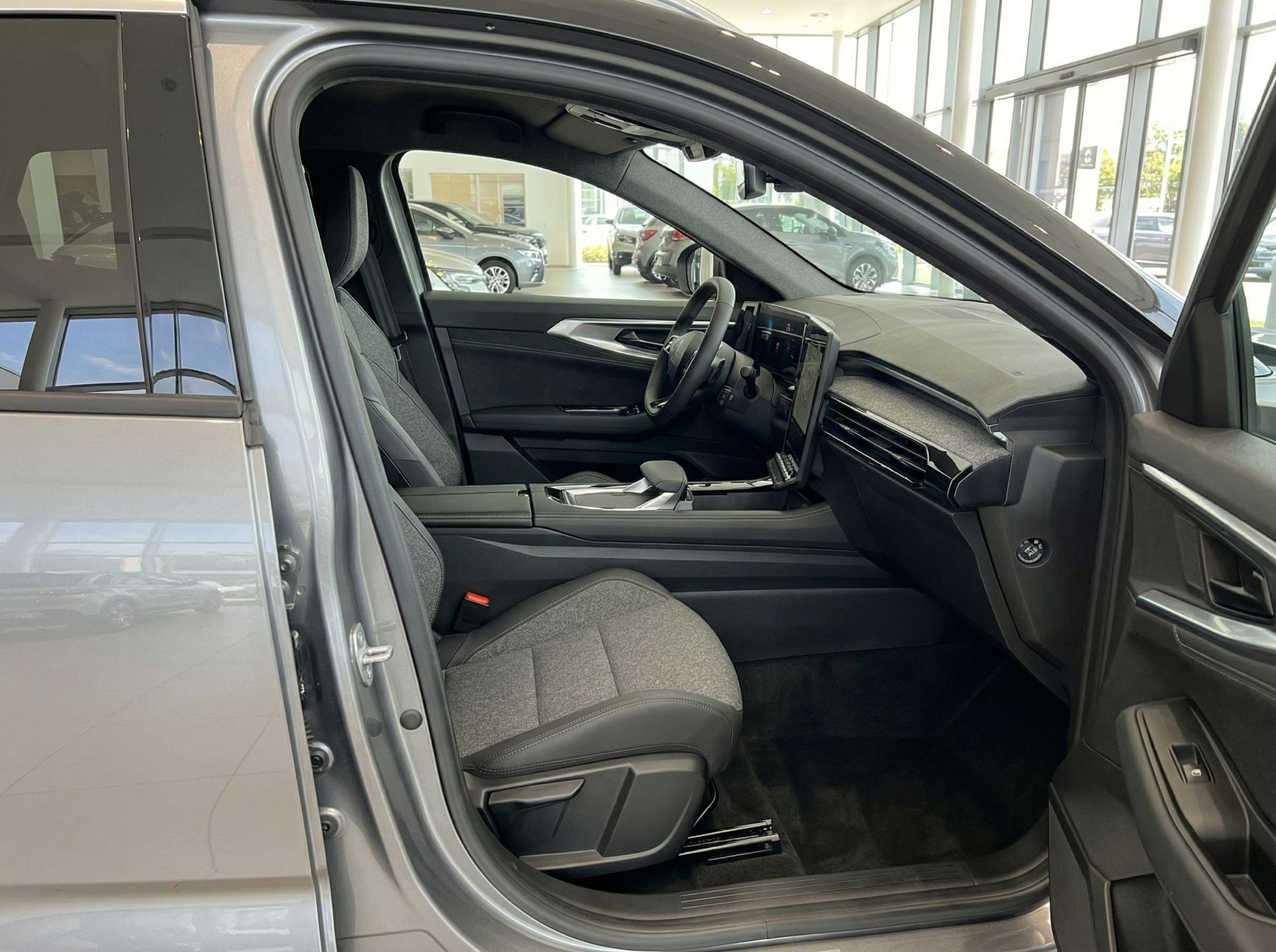 Fahrzeug Innenraum Beifahrerseite mit grauen Sitzen und offener Tür im Autohaus