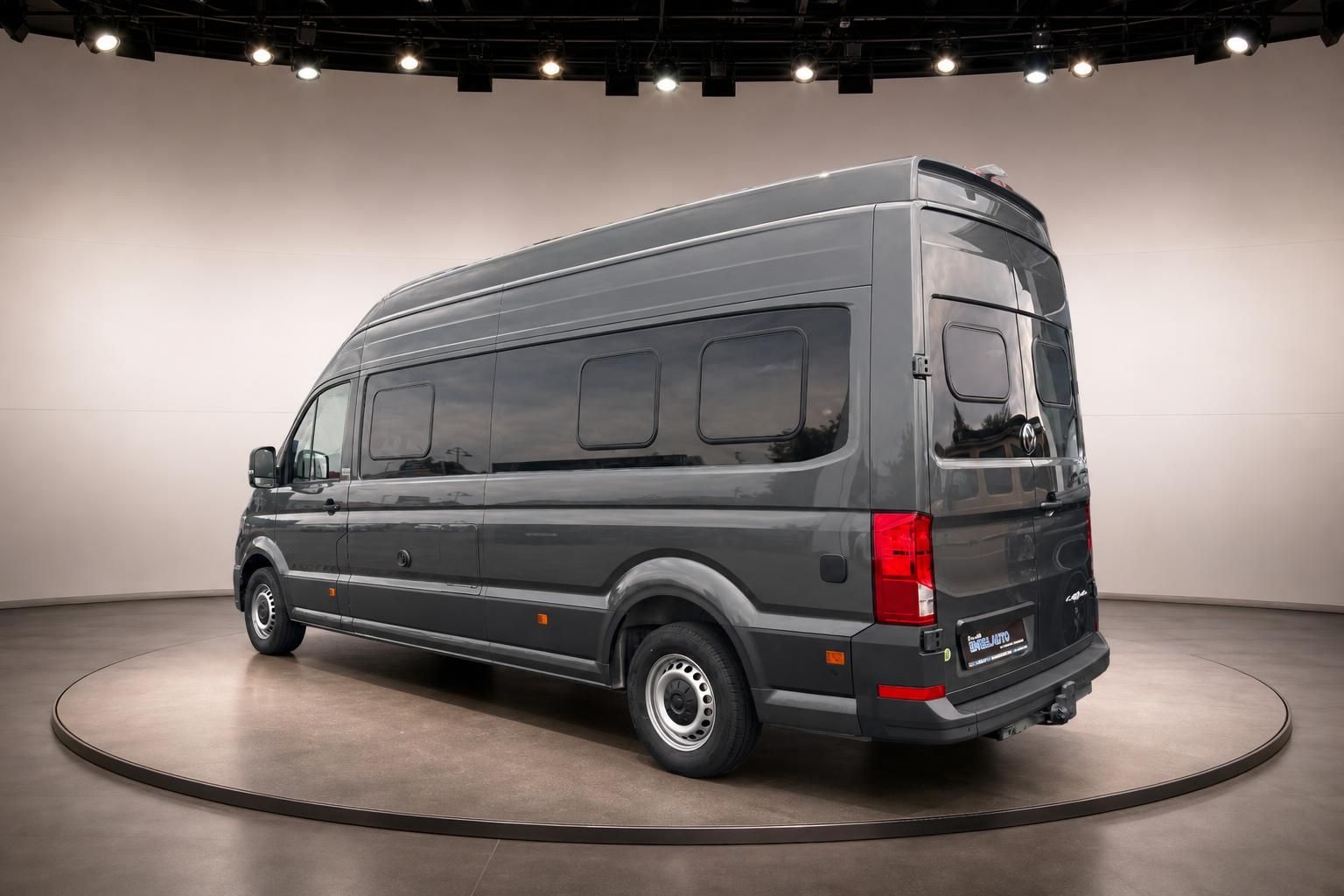 VW Crafter Schrägansicht hinten - grauer Kastenwagen mit Solarpanel und professionellem Wohnmobil-Ausbau