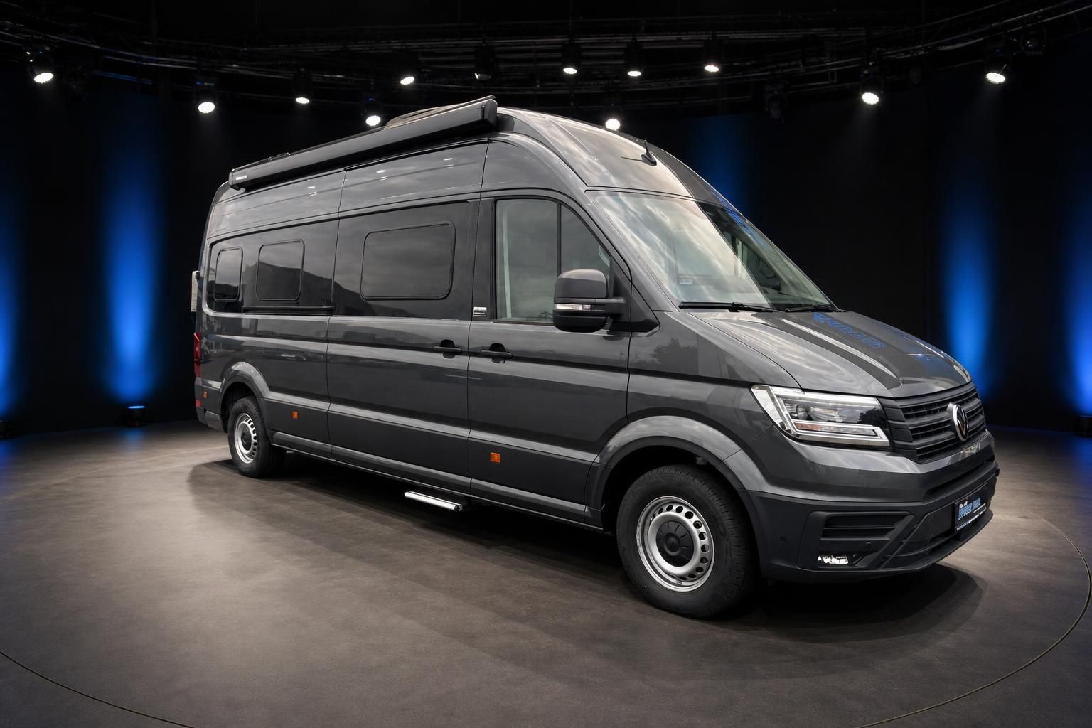 VW Crafter Seitenansicht grauer Hochdach-Transporter mit Fenstern im Showroom von vorne links