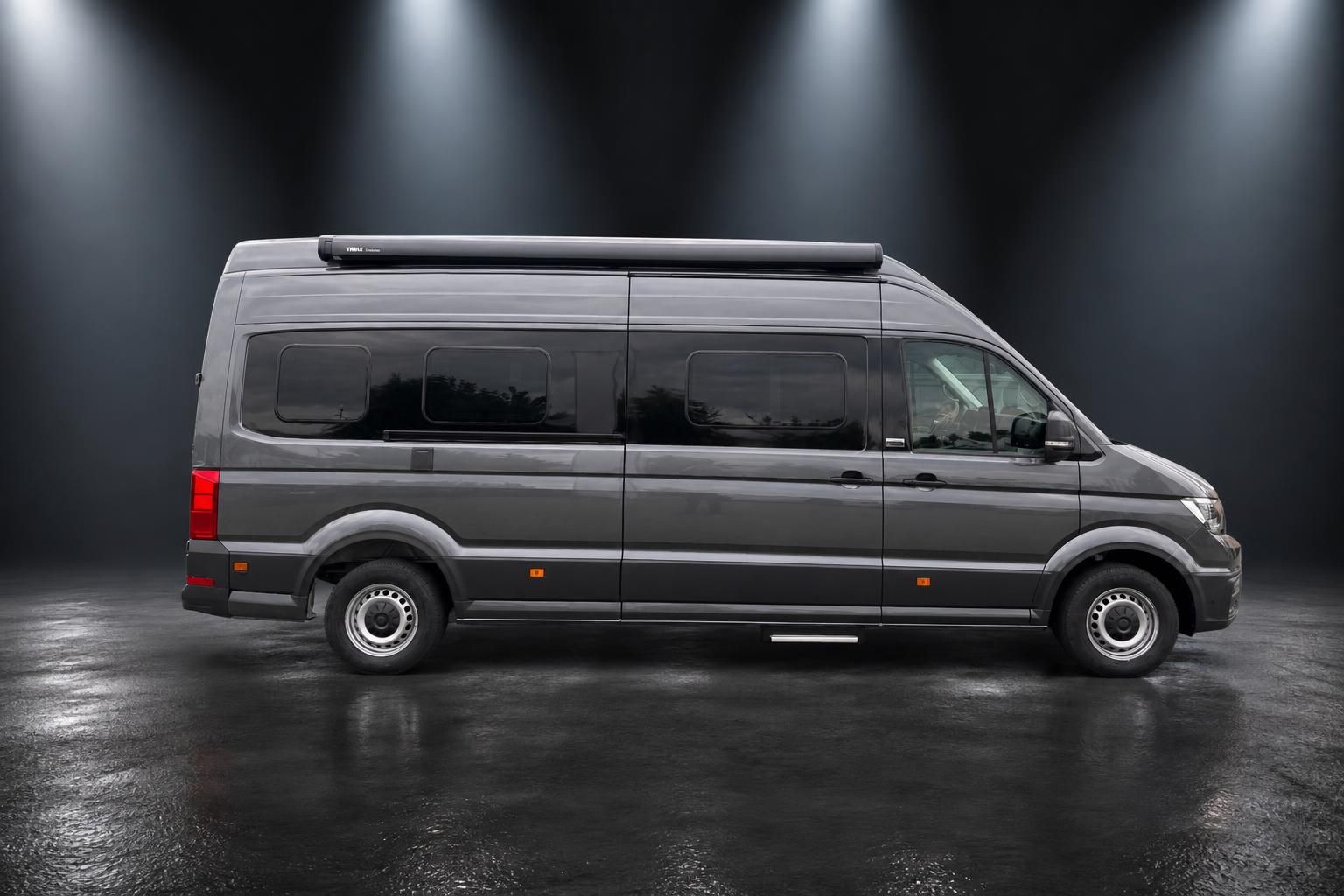 VW Crafter Seitenansicht grauer Transporter mit Thule Dachbox und Fenstern von der Seite
