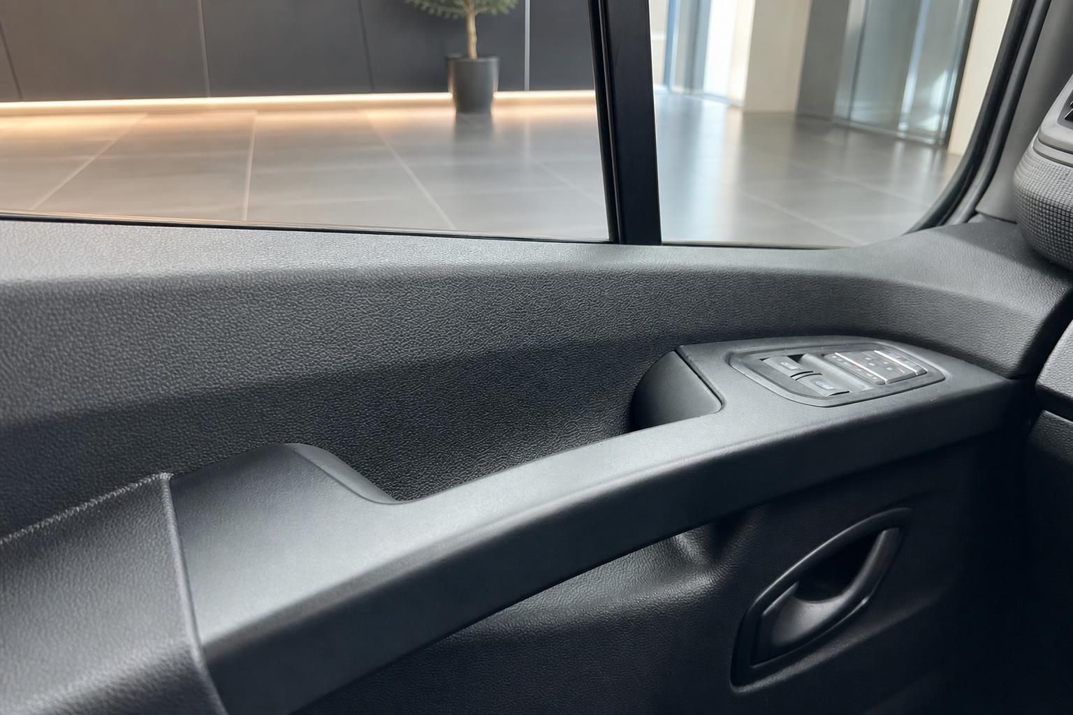 Türverkleidung mit Fensterheber-Schaltern und grauer Kunststoffverkleidung