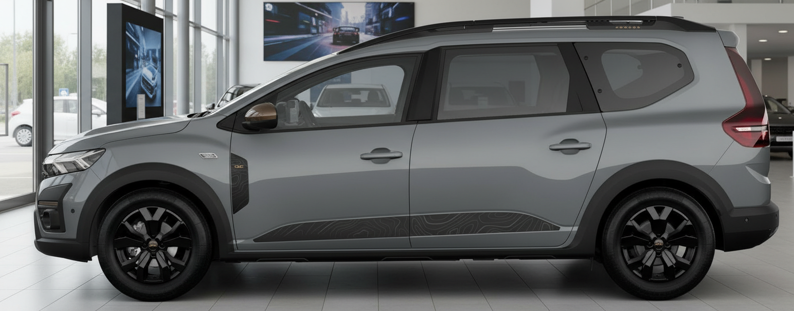 Grauer Dacia Jogger Seitenansicht im Autohaus mit schwarzen Felgen und Dachreling