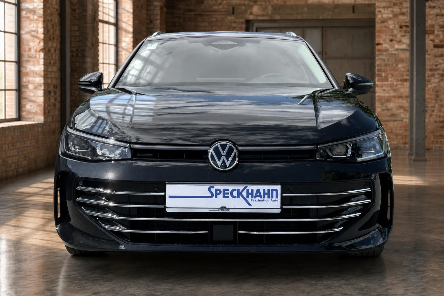 VW Passat schwarz Frontansicht mit VW-Emblem in Ausstellungshalle