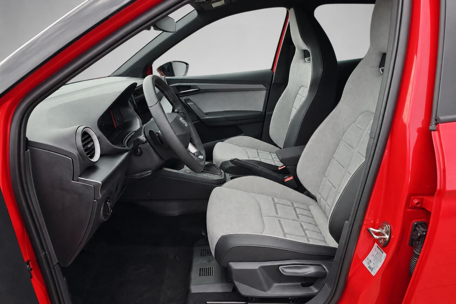 Innenraum SEAT Arona mit grauen Stoffsitzen und Cockpit, Blick durch Fahrertür