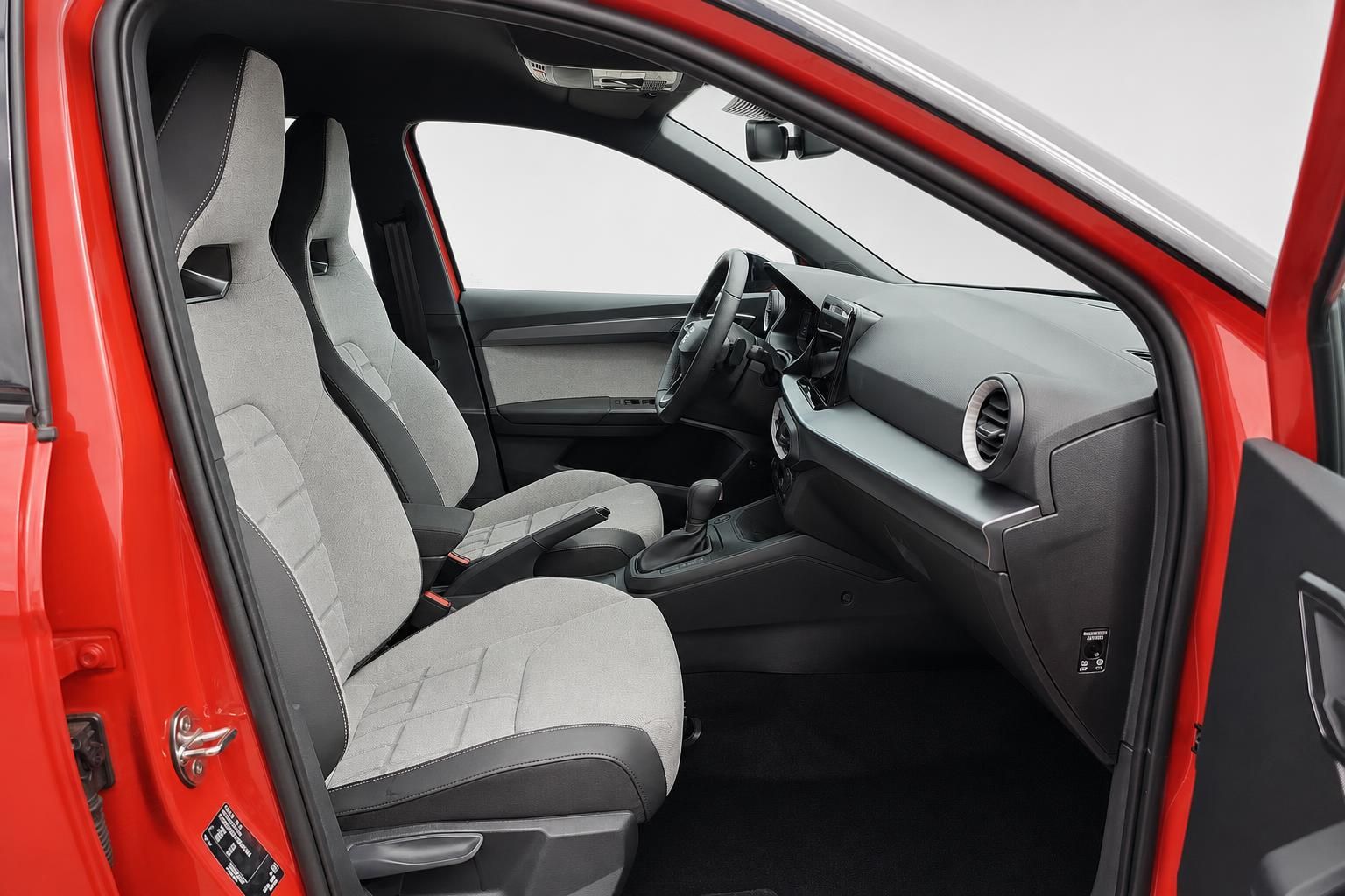 Fahrersitz und Armaturenbrett des SEAT Arona mit Schaltgetriebe, Blick durch Tür