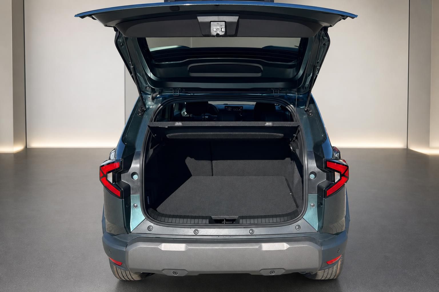 Kofferraum eines blauen SUVs mit geöffneter Heckklappe und Laderaum in Studiobeleuchtung