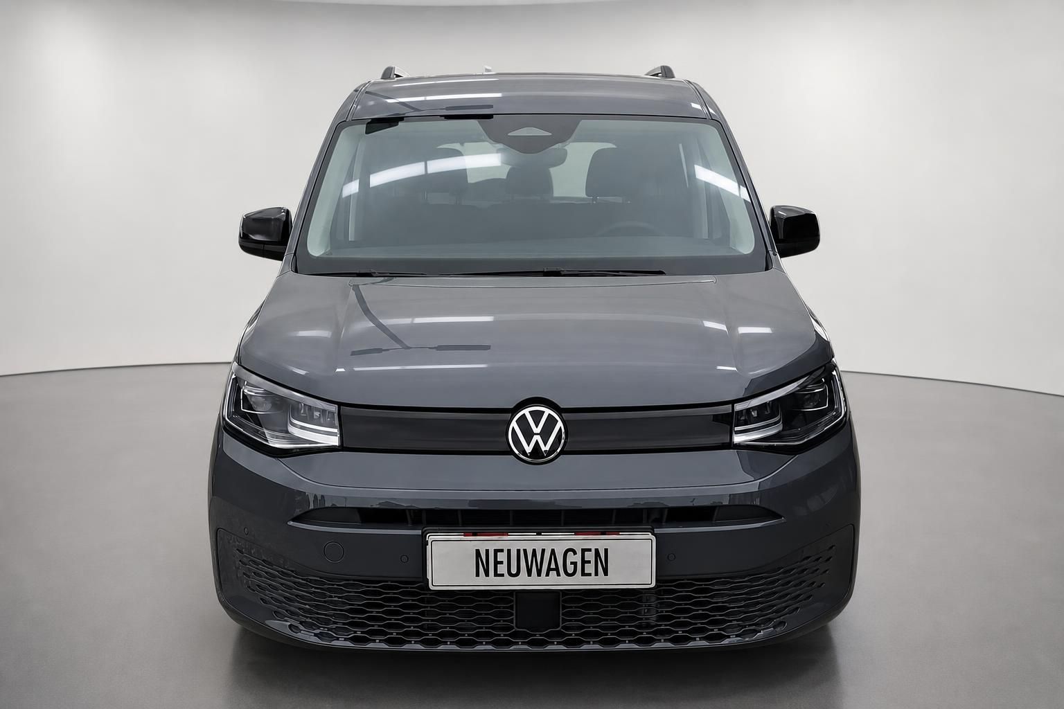 VW Caddy grau, Frontansicht mit VW-Logo im Studio