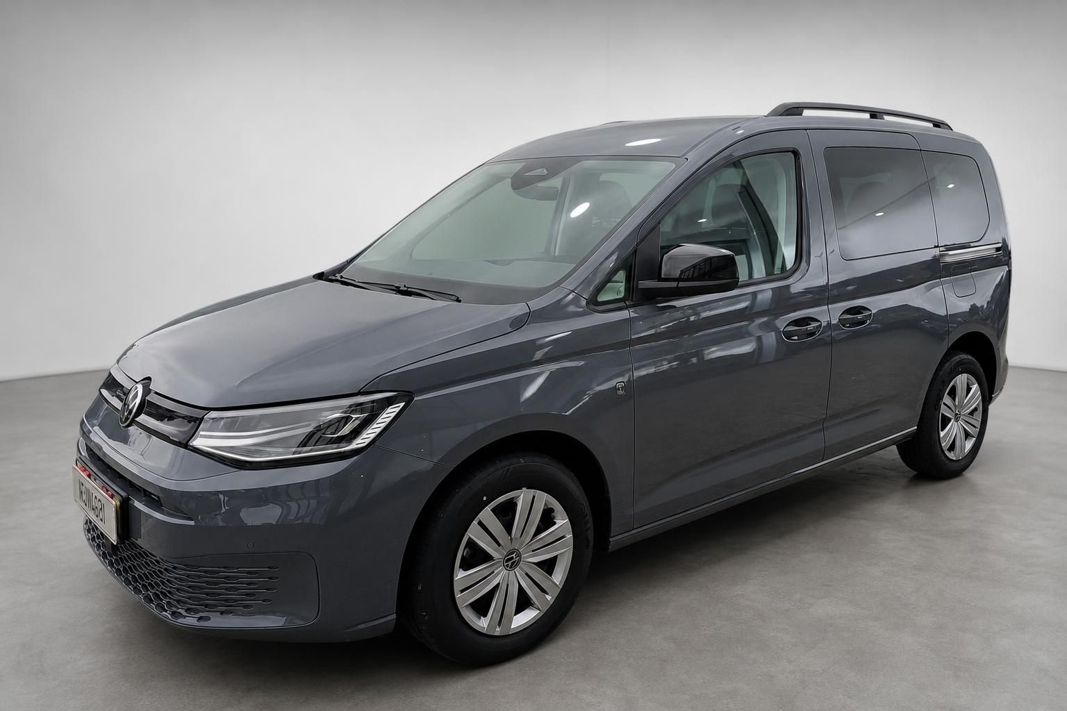 VW Caddy grau, Frontansicht schraeg im Studio