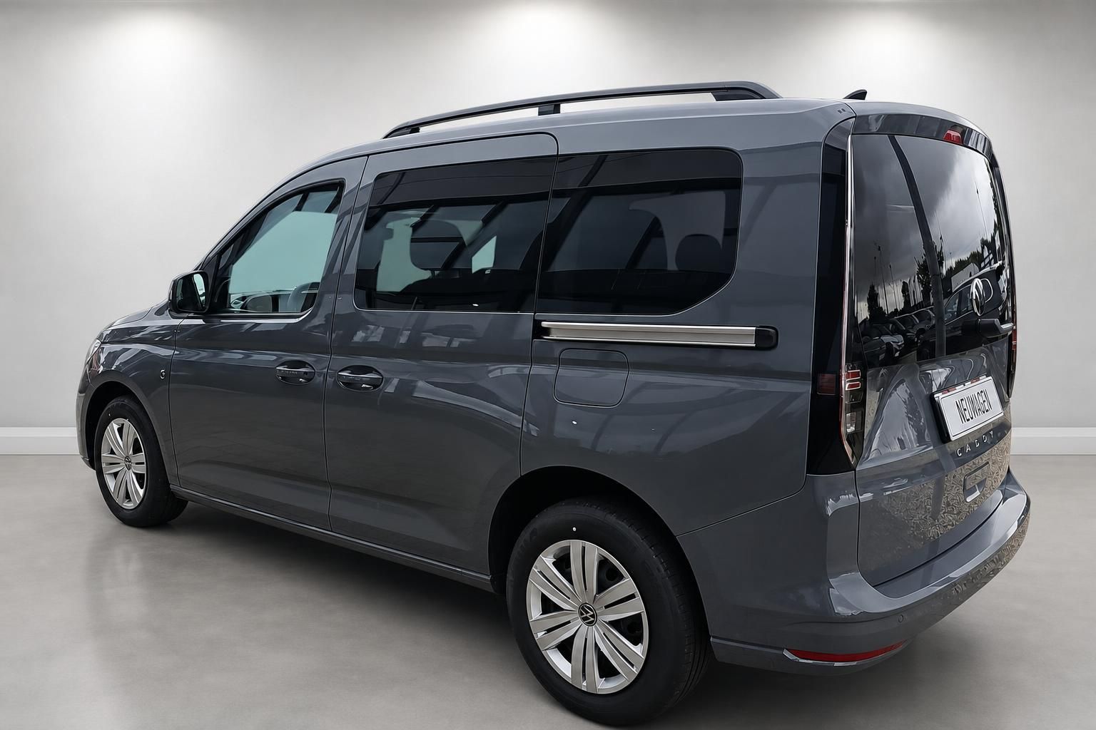 VW Caddy grau, Heckansicht seitlich im Studio