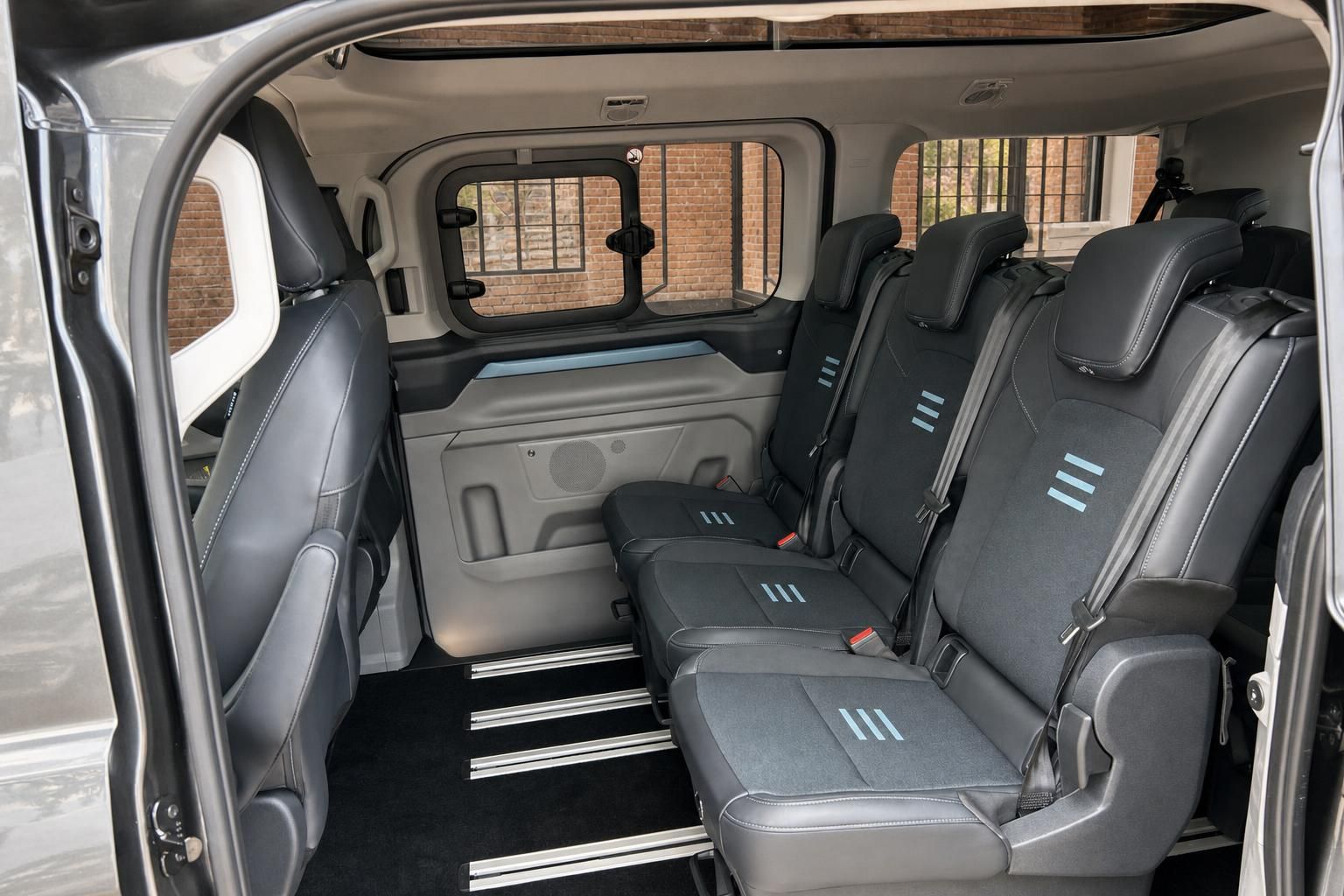 Ford Transit Custom Innenraum Rücksitzbank mit schwarzen Ledersitzen und Schiebetür geöffnet