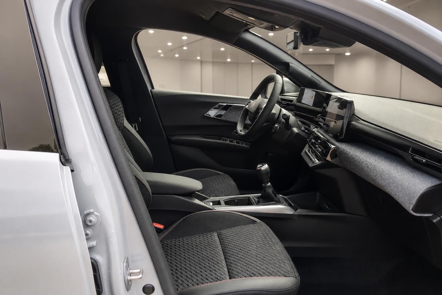 Blick durch geöffnete Fahrertür auf Cockpit und Schaltung des Fahrzeugs
