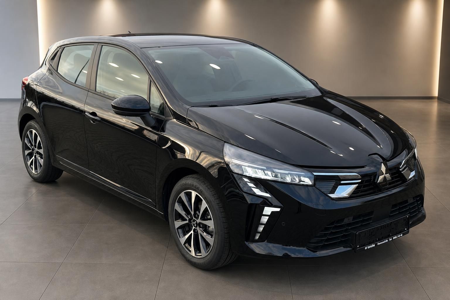 Schwarzer Mitsubishi Kompaktwagen Frontansicht schraeg im Showroom