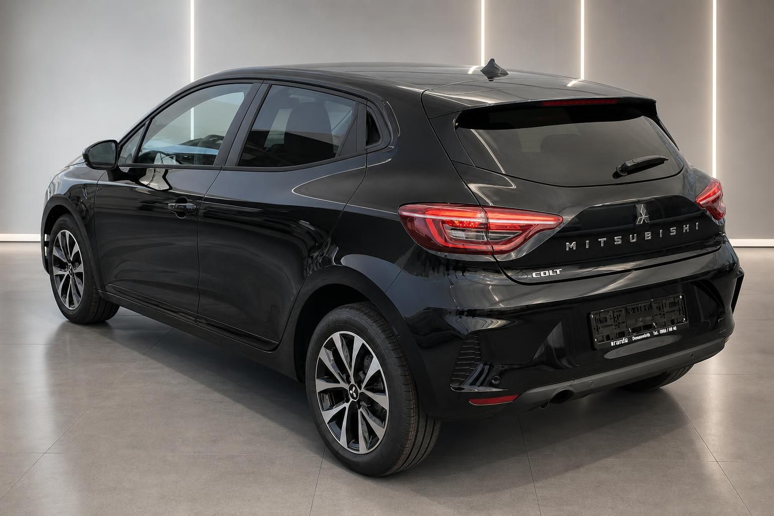 Mitsubishi Colt schwarz, Heckansicht schräg im Showroom