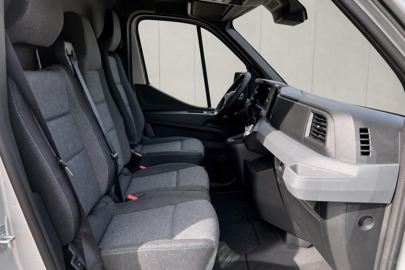 Innenraum eines Transporters mit grauen Stoffsitzen und modernem Dashboard