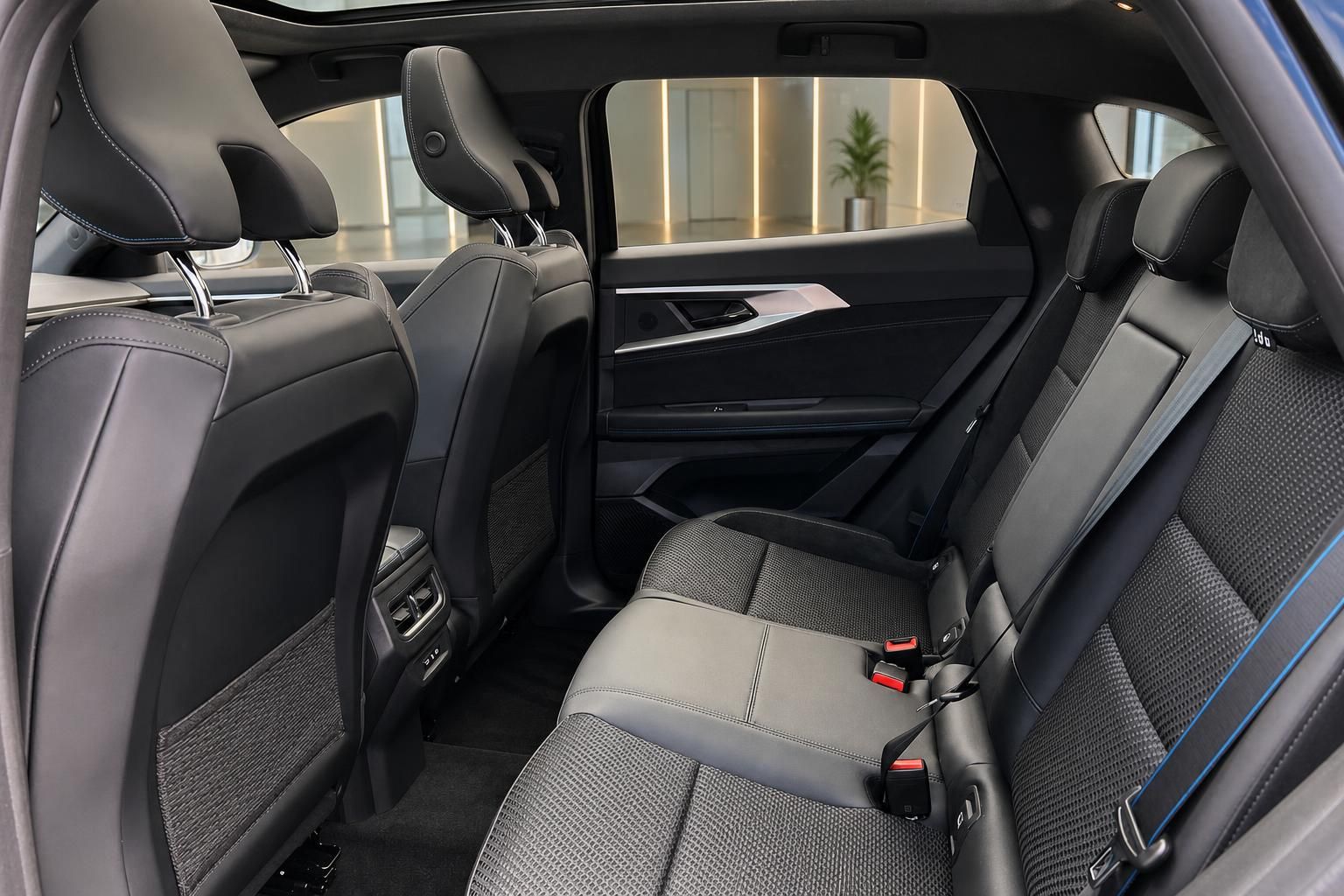 Rueckbank mit schwarzen Lederpolstern und blauen Kontrastnaehten im SUV