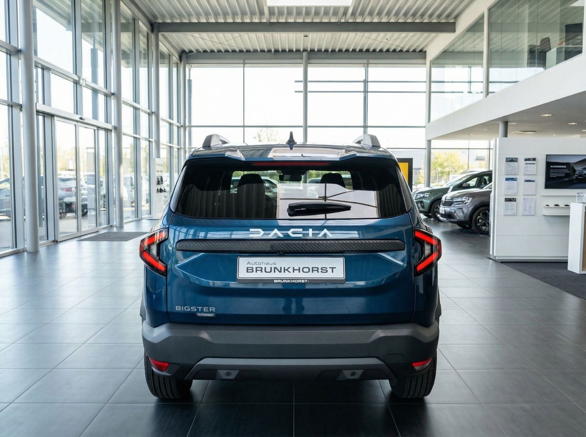 Dacia Bigster Heckansicht in blauer Metallic-Lackierung im Autohaus-Showroom