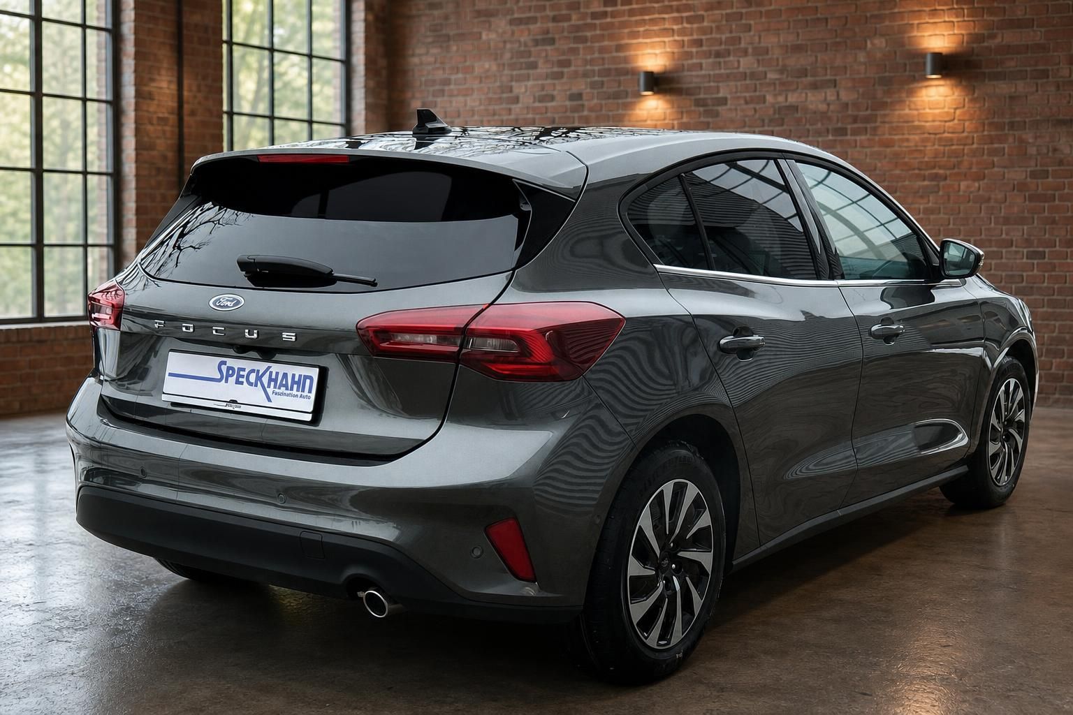 Ford Focus grau Heckdiagonale mit Leichtmetallfelgen und Ziegelwand im Hintergrund