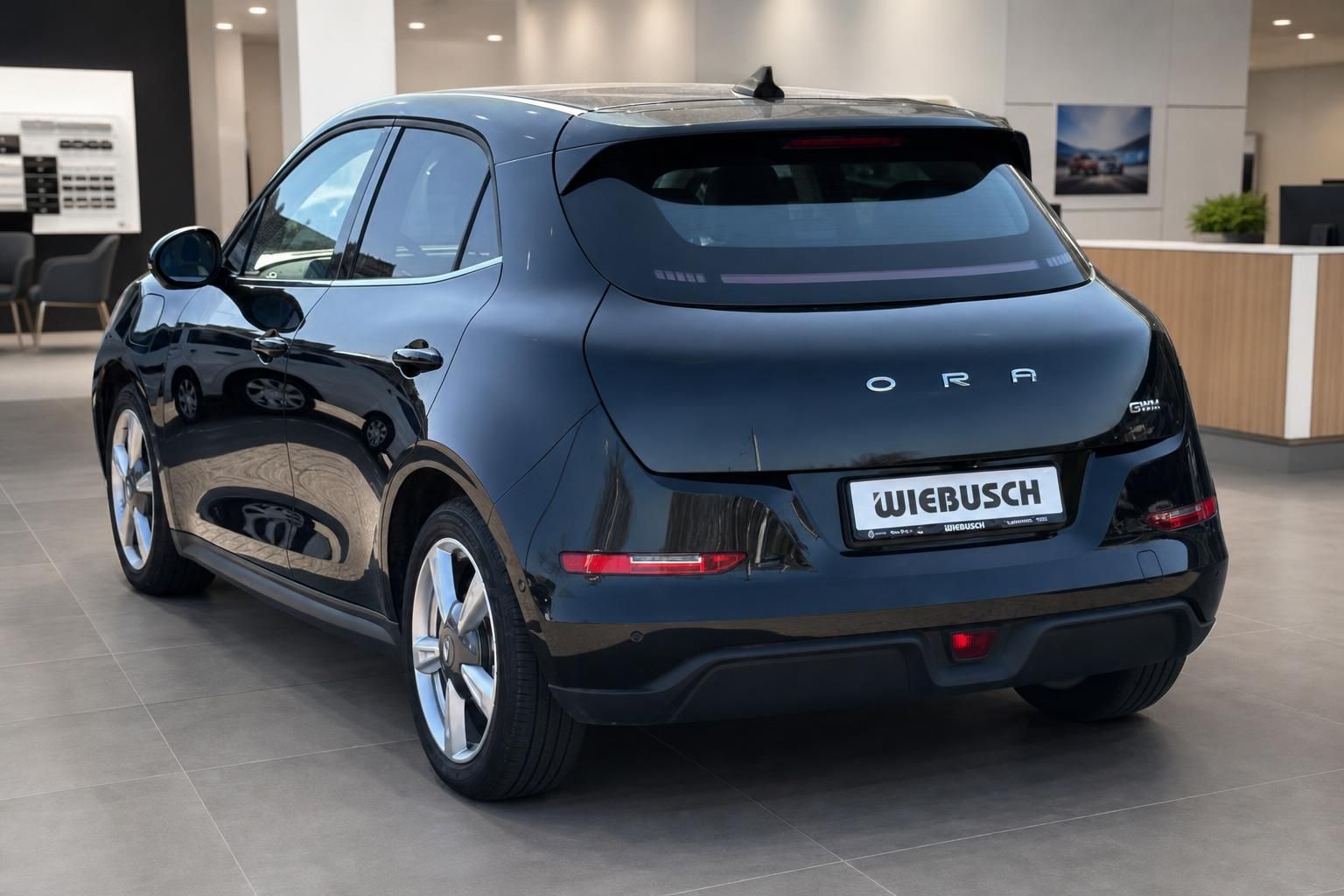 Schwarzer SUV von schräg hinten im Autohaus, moderne Elektrofahrzeug-Silhouette mit Sportfelgen