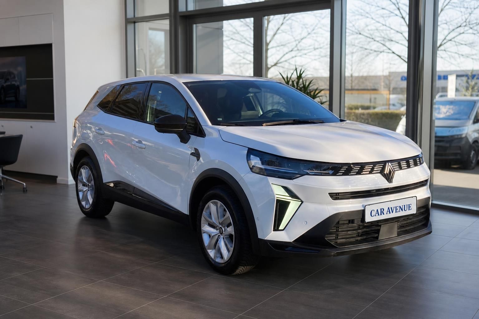 Renault Symbioz SUV Frontansicht in weiß mit charakteristischem LED-Tagfahrlicht im Showroom