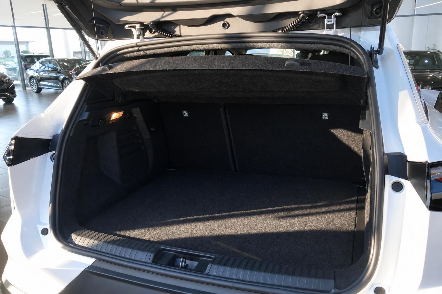 Fahrzeug Kofferraum geöffnet mit dunklem Teppichboden und Ladekante im Autohaus