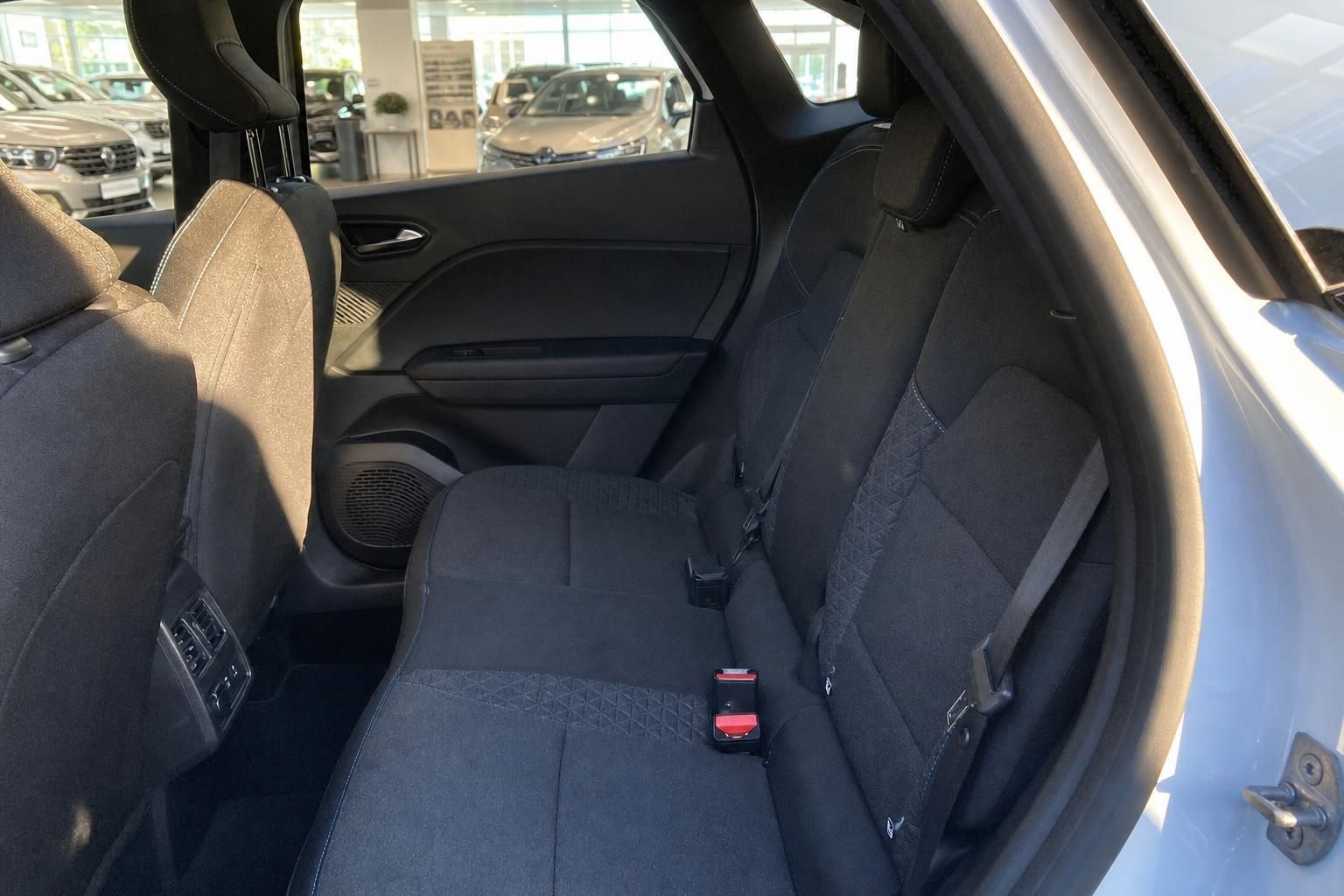 Fahrzeug Rücksitzbereich mit dunklen Stoffsitzen und Sicherheitsgurten im Autohaus